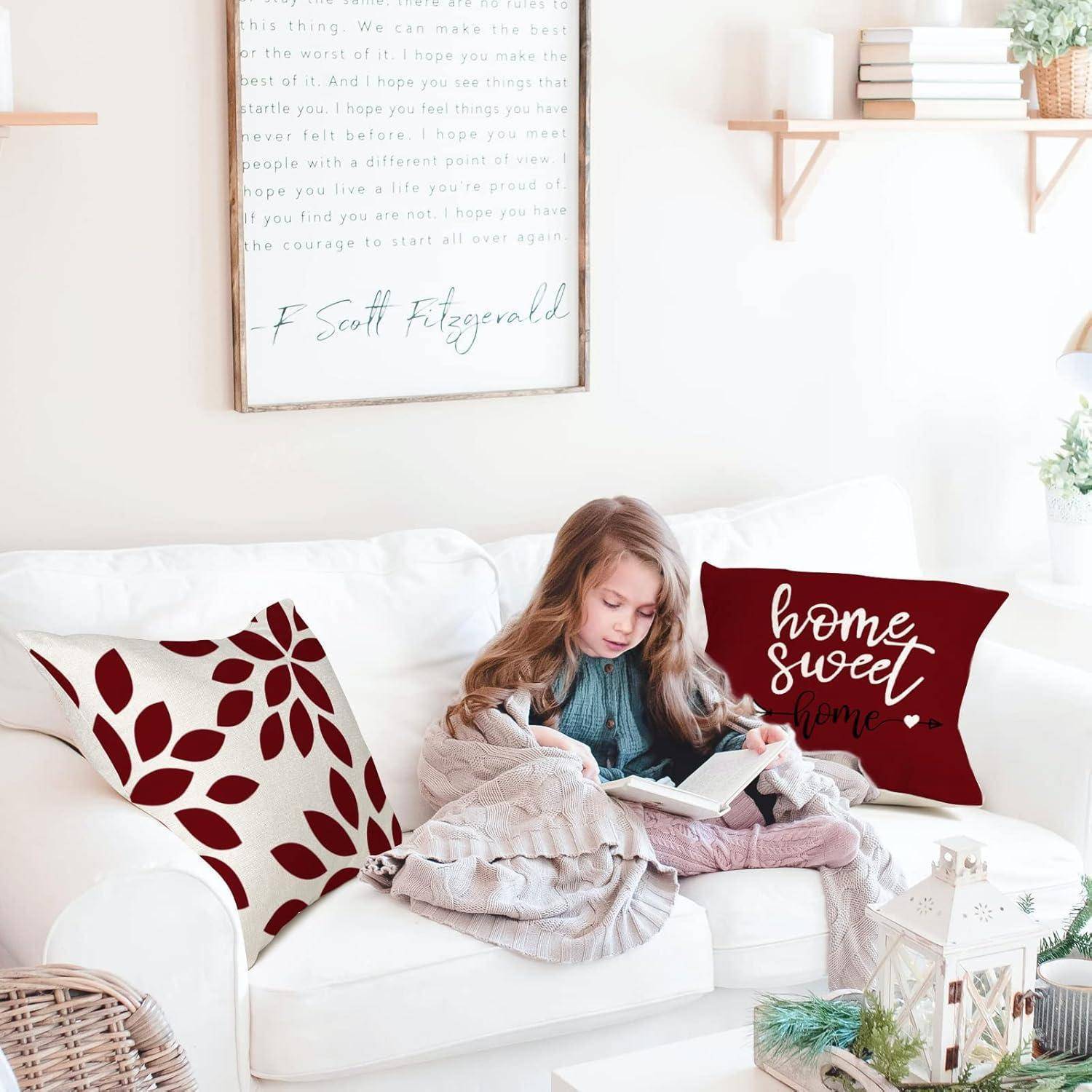 Ein junges Mädchen sitzt auf einem weißen Sofa, in eine Decke gehüllt, und liest ein Buch. Dekorative Kissen und Regale mit Büchern und Pflanzen sind zu sehen.