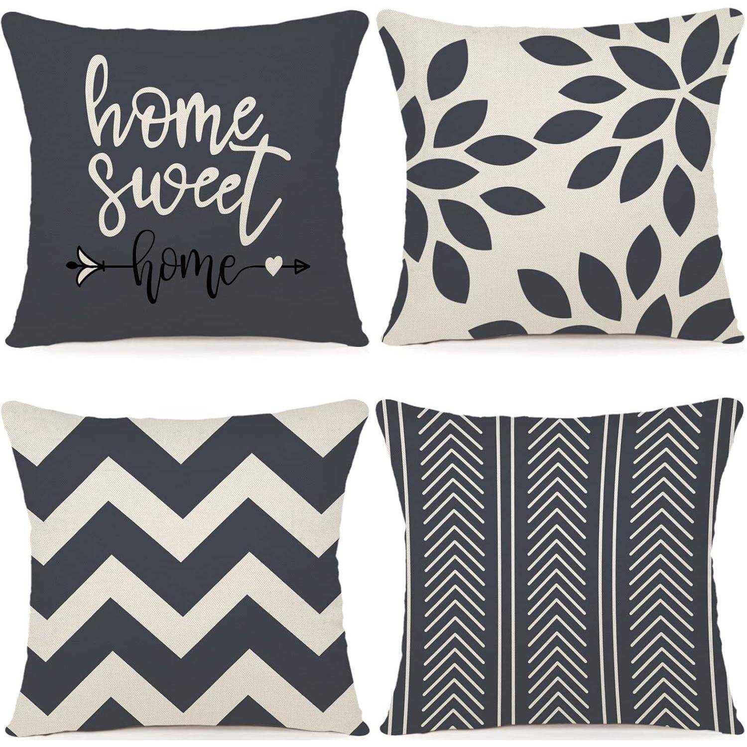Vier dekorative Zierkissen mit unterschiedlichen Mustern: Schriftzug 'home sweet home', Blattdesign, Zickzackmuster und vertikale Streifen.