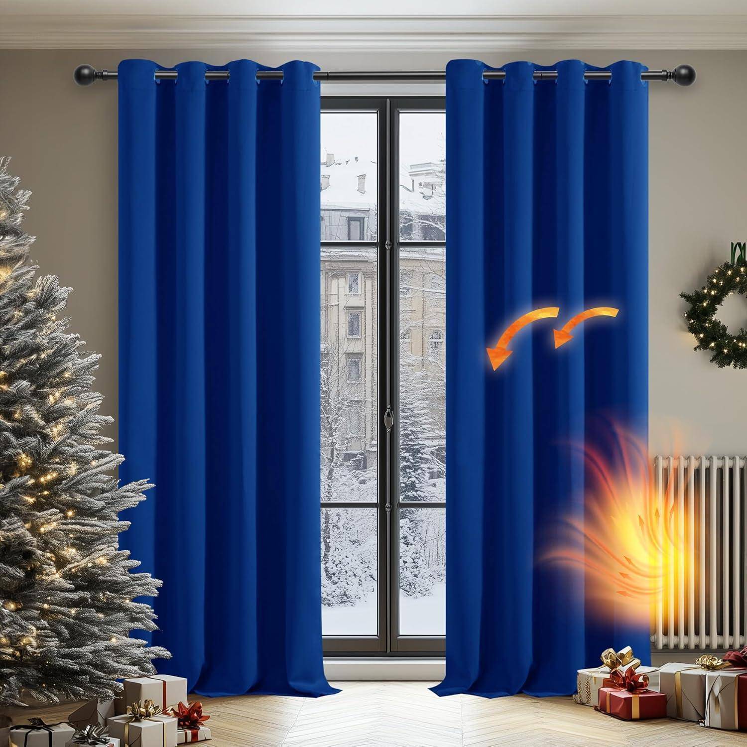 Blaue Vorhänge sind halb zugezogen in einem Raum mit verschneitem Fensterblick, ein Weihnachtsbaum im Vordergrund und ein kleines Feuer neben dem Heizkörper.