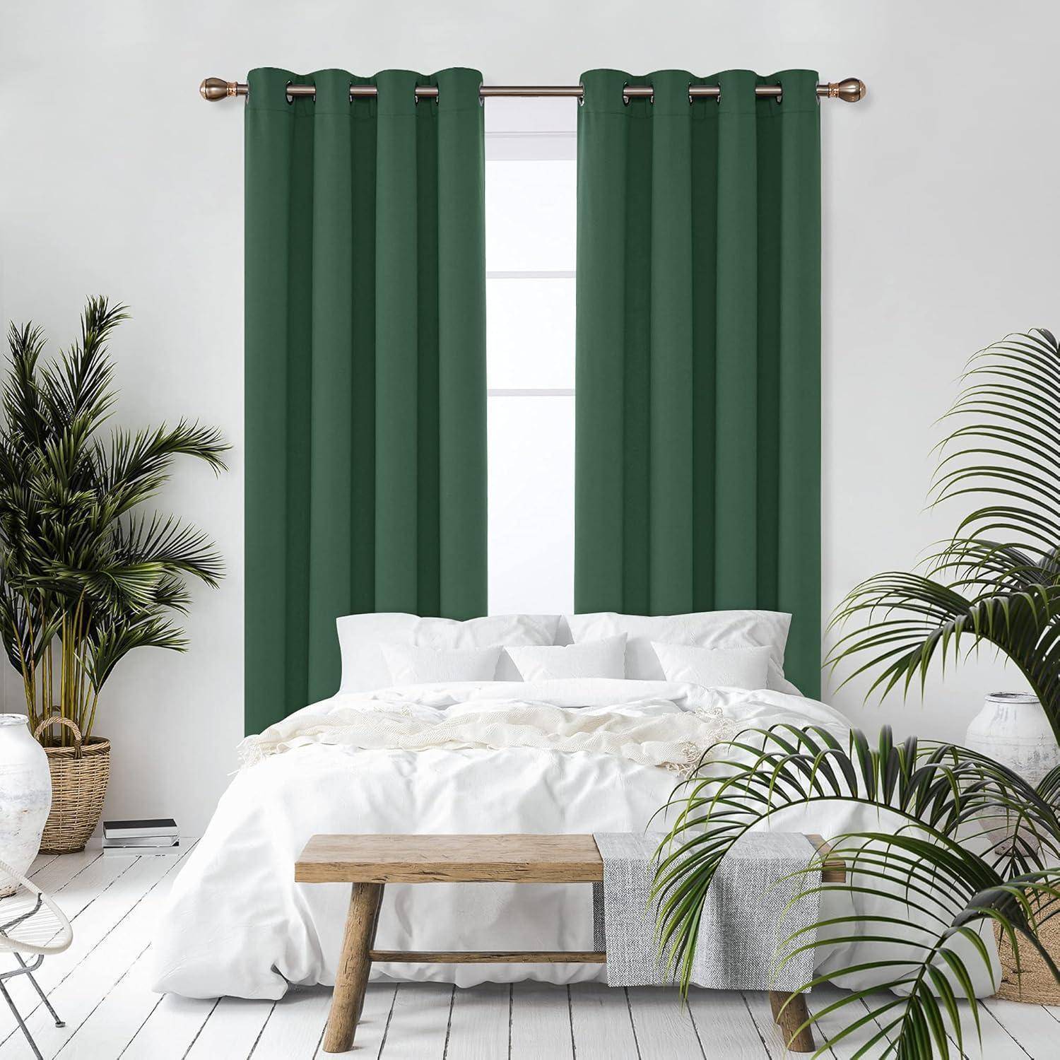 Ein Schlafzimmer mit einem sauber bezogenen weißen Bett, grünen Vorhängen, einer Holzbank und umgebenden Zimmerpflanzen, die eine ruhige und natürliche Atmosphäre schaffen.