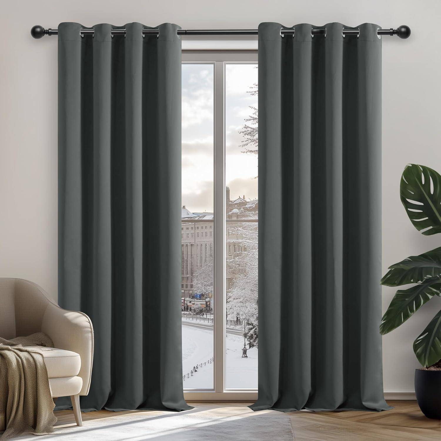 Ein Wohnzimmerfenster mit grauen Vorhängen blickt auf eine verschneite Stadtlandschaft. Ein beiger Stuhl mit einer Decke und einer grünen Pflanze sind vorhanden.