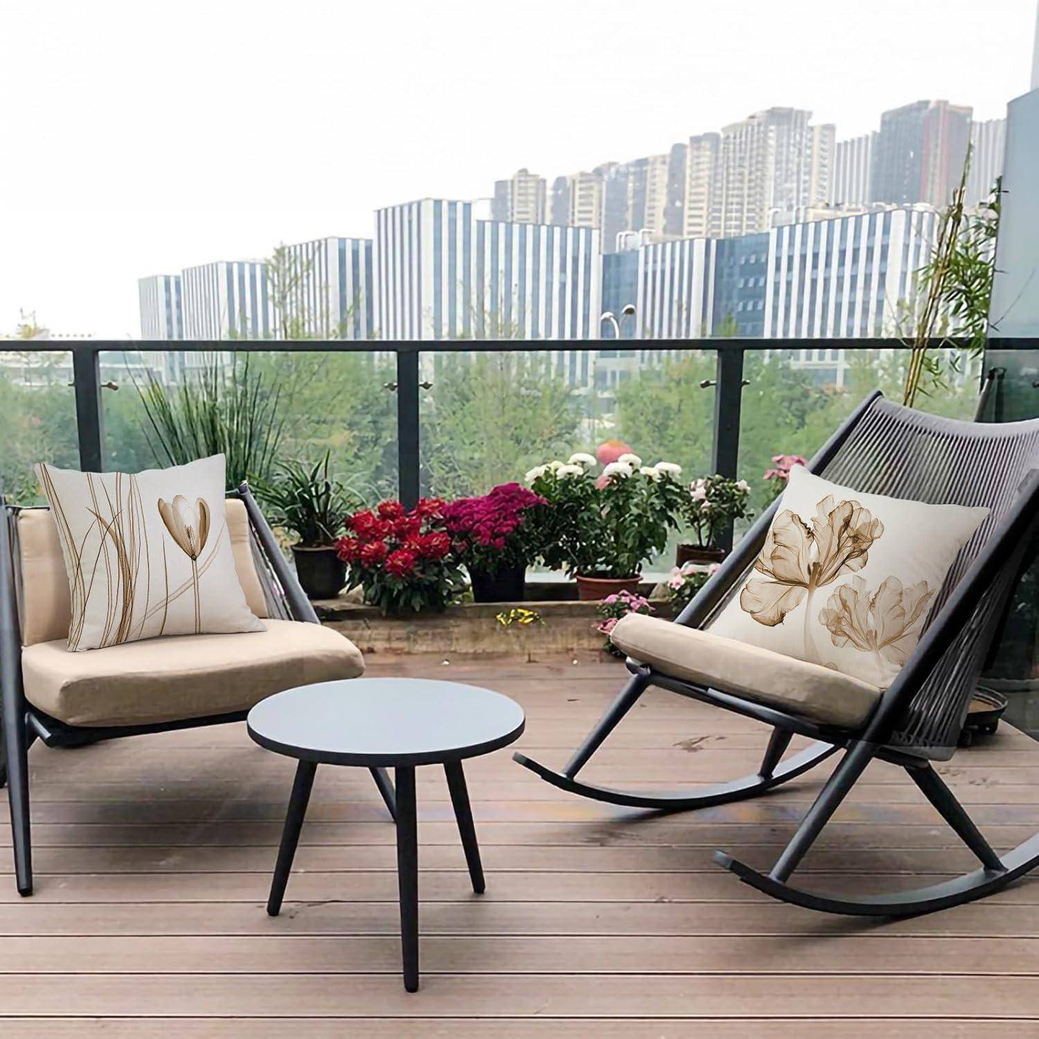 Eine moderne Terrasse verfügt über zwei Stühle mit Blumenkissen, einen kleinen runden Tisch und einen Blick auf Stadtgebäude und Grünflächen.