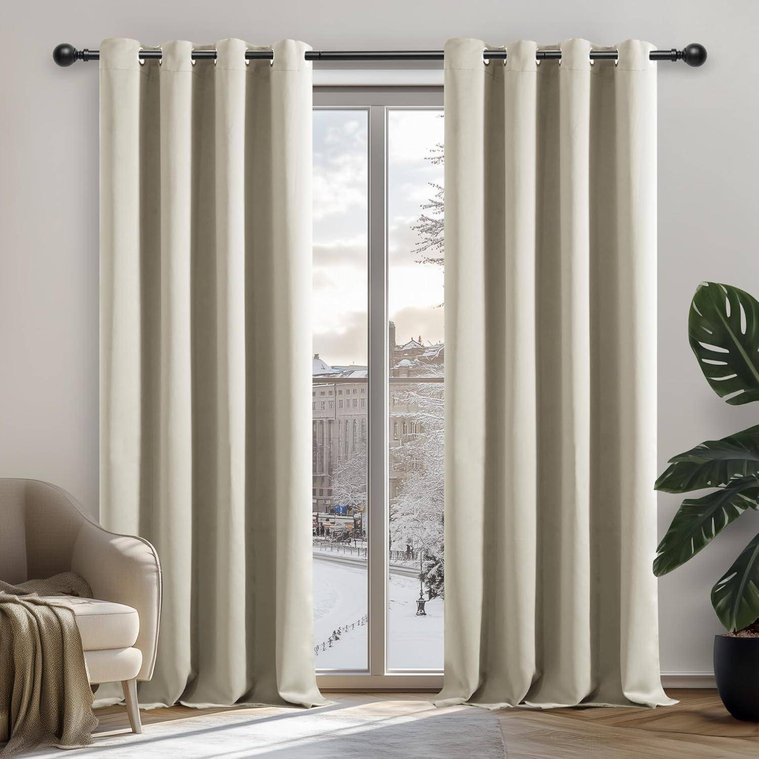 Cremefarbene Vorhänge, die an einer Stange hängen, rahmen ein Fenster mit einer verschneiten Stadtlandschaft ein. Rechts ein gemütlicher Sessel mit einer Kuscheldecke und einer Pflanze.