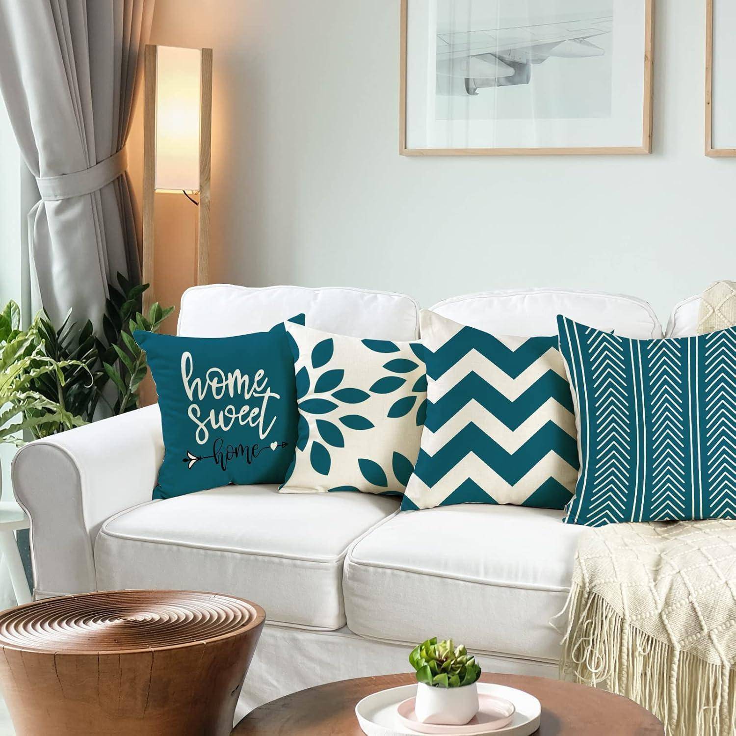Ein weißes Sofa mit vier dekorativen Kissen, darunter eines mit dem Text „Home Sweet Home