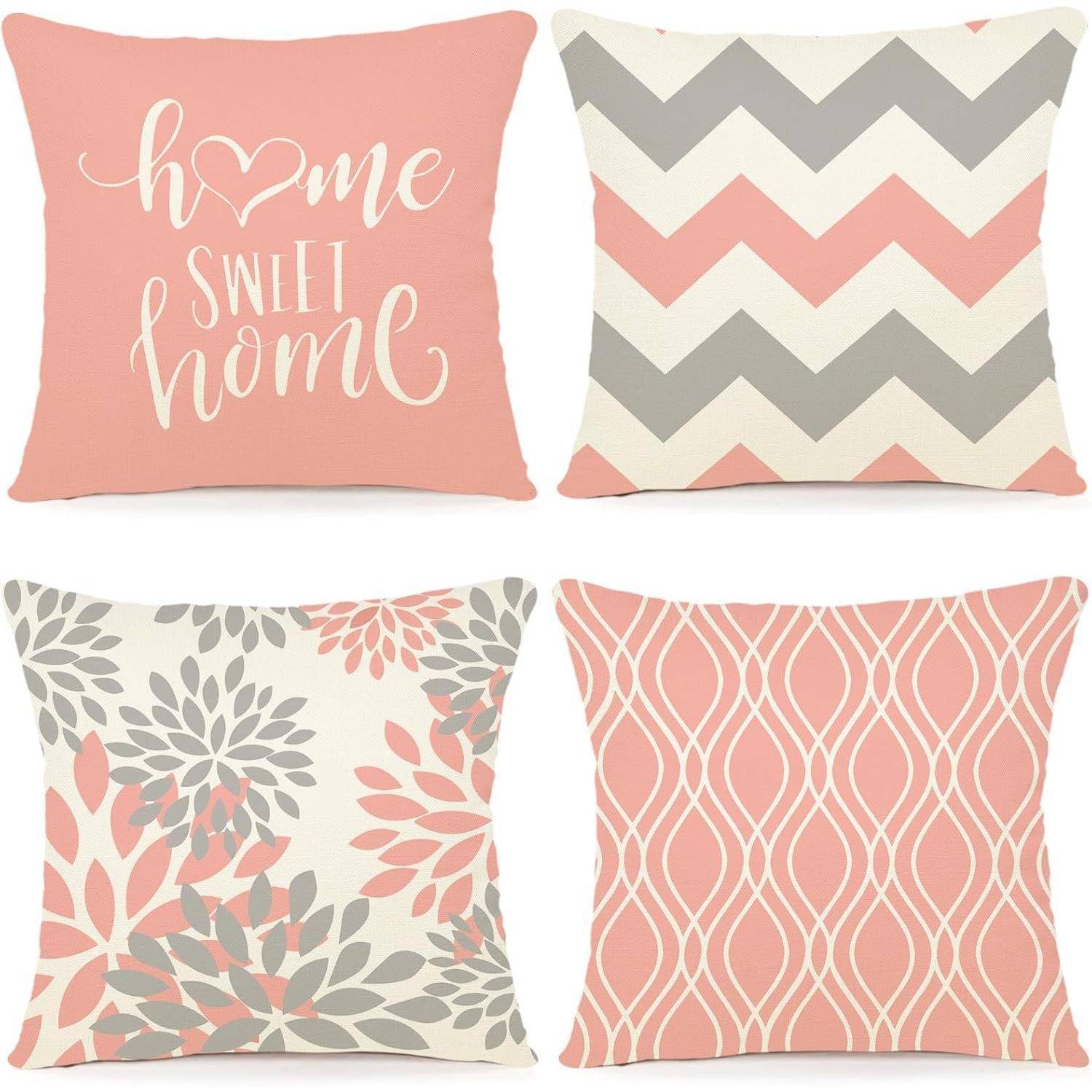 Vier dekorative Zierkissen in zartem Rosa und Grau mit folgenden Designs: Schriftzug 'home sweet home', Zickzackmuster, Blumenmuster und geometrische Formen.