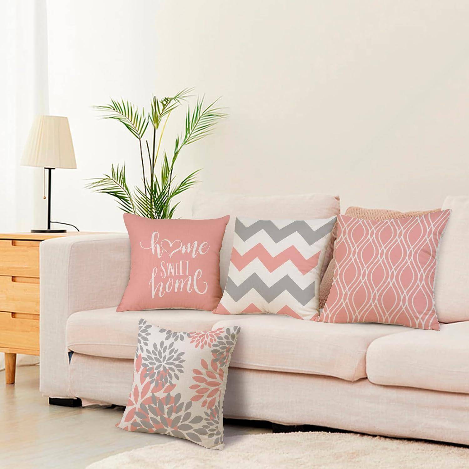 Sofa mit dekorativen Kissen in verschiedenen Mustern und Farben, eines davon mit dem Text ‚home sweet home'; Lampe und Pflanze im Hintergrund.