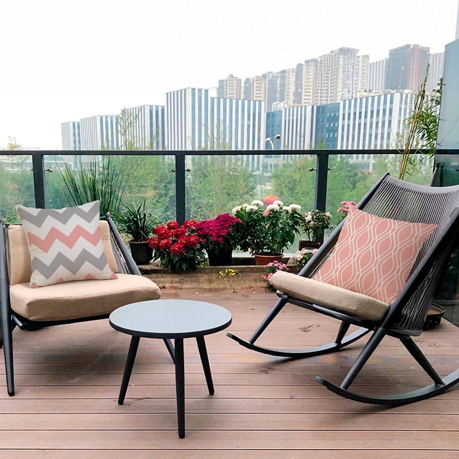 Dachterrasse mit zwei Stühlen, einem kleinen Tisch, dekorativen Kissen und Stadtgebäuden im Hintergrund, die einen gemütlichen Sitzbereich bietet.
