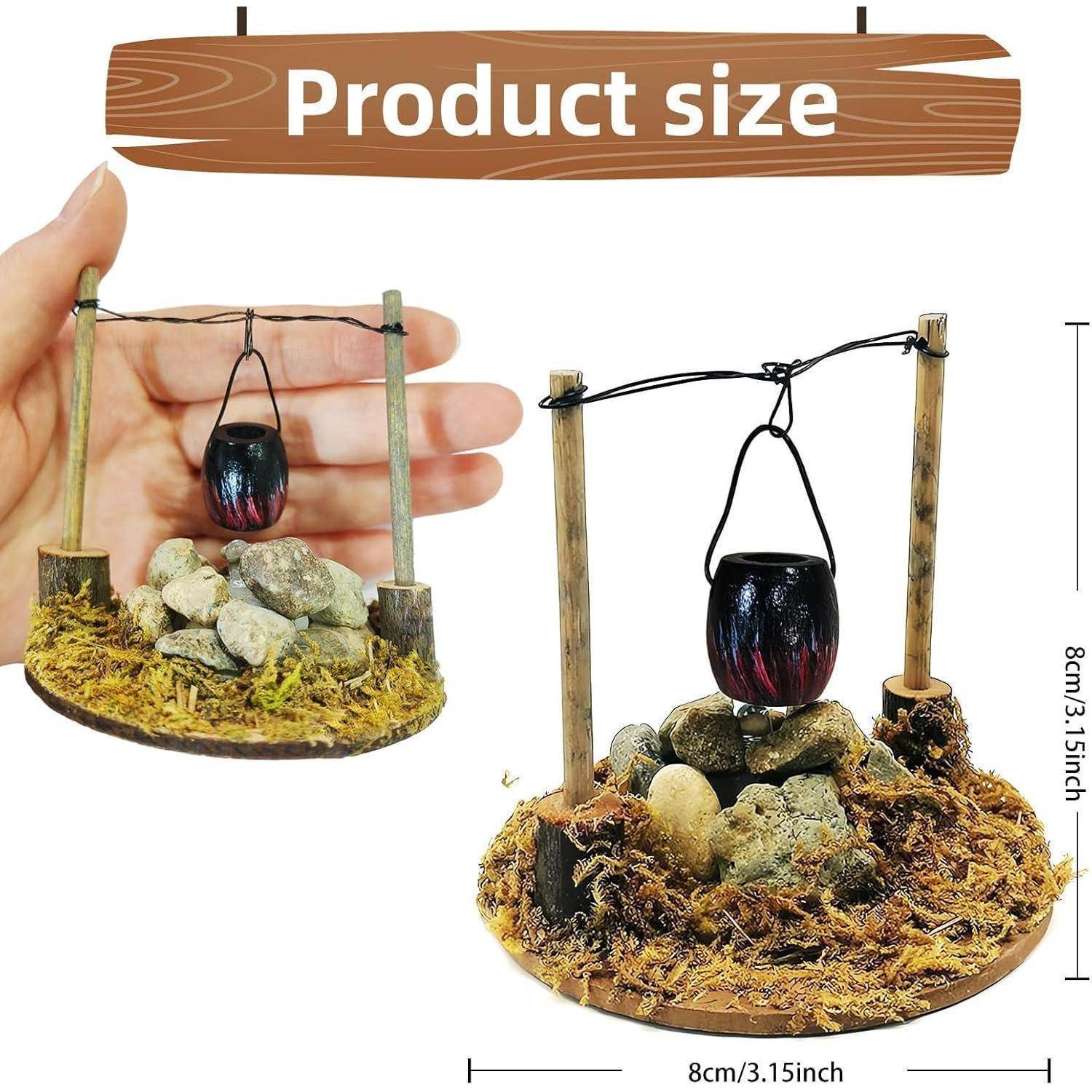 Produktgröße: Text mit einer Miniatur-Campingszene, auf der ein Topf über Steinen hängt. Hand zur Größenbestimmung gezeigt. Größe: 8 cm/3,15 Zoll.