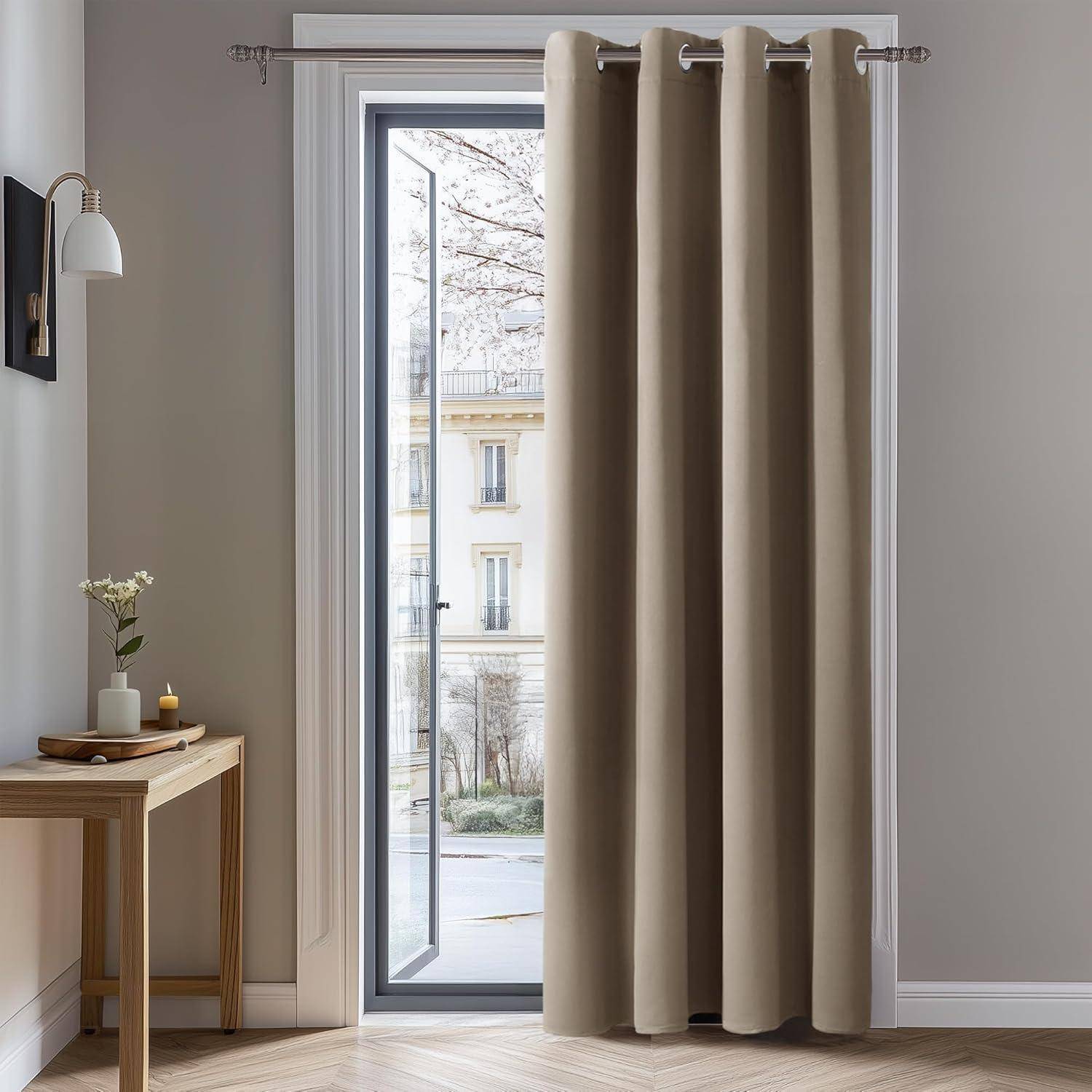 Ein Raum mit beigen Vorhängen vor einem hohen Fenster, einem kleinen Holztisch mit einer Blumenvase und einem Blick auf Gebäude draußen.