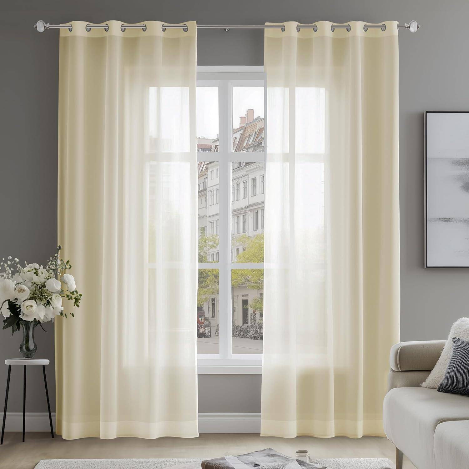 Ein heller Wohnraum mit transparenten beigen Vorhängen, einer Vase mit weißen Blumen auf einem kleinen Tisch und einem großen Fenster, das einen Stadtblick offenbart.