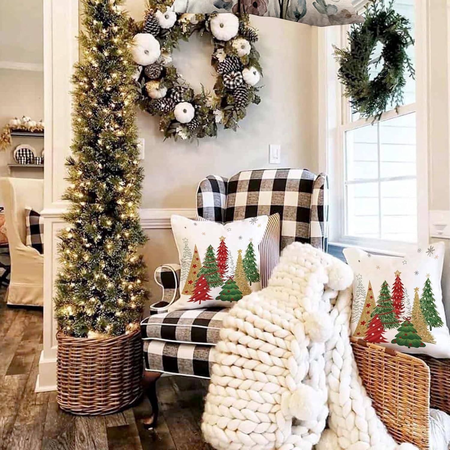 Ein gemütliches, weihnachtlich gestaltetes Wohnzimmer mit einem karierten Sessel, festlichen Kissen mit Weihnachtsbäumen, einer gestrickten Decke und einem geschmückten Kranz an der Wand.
