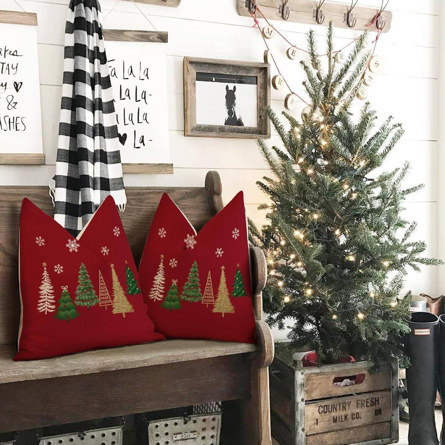 Ein gemütliches Weihnachtszimmer mit einem geschmückten Weihnachtsbaum, roten Kissen mit Tannenbaummuster auf einer Bank, gestreiften Vorhängen und gerahmten Wandbildern.
