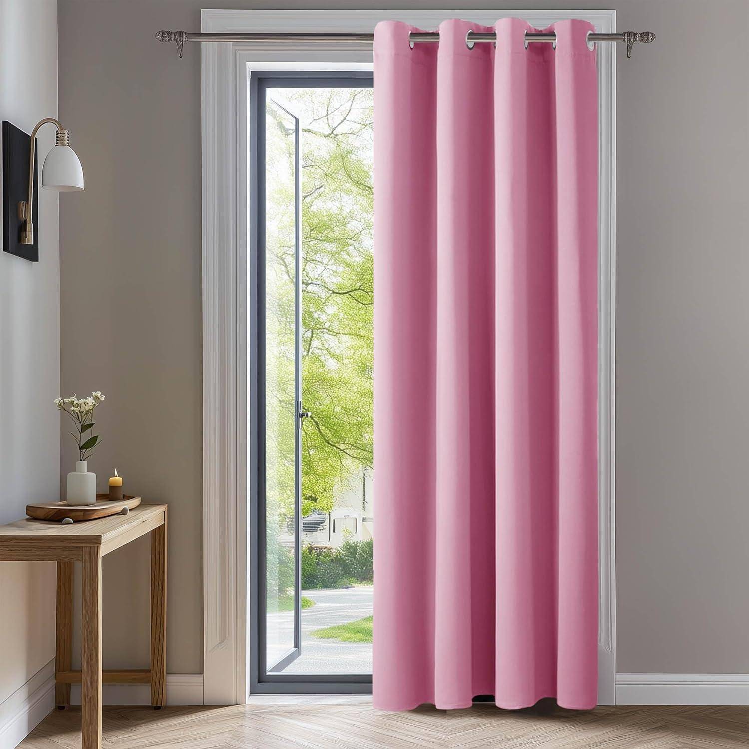 Ein hell erleuchteter Raum mit einem hohen Fenster, das von rosa Vorhängen verhüllt wird. Ein kleiner Holztisch mit einer Lampe und einer Blumenvase steht links.