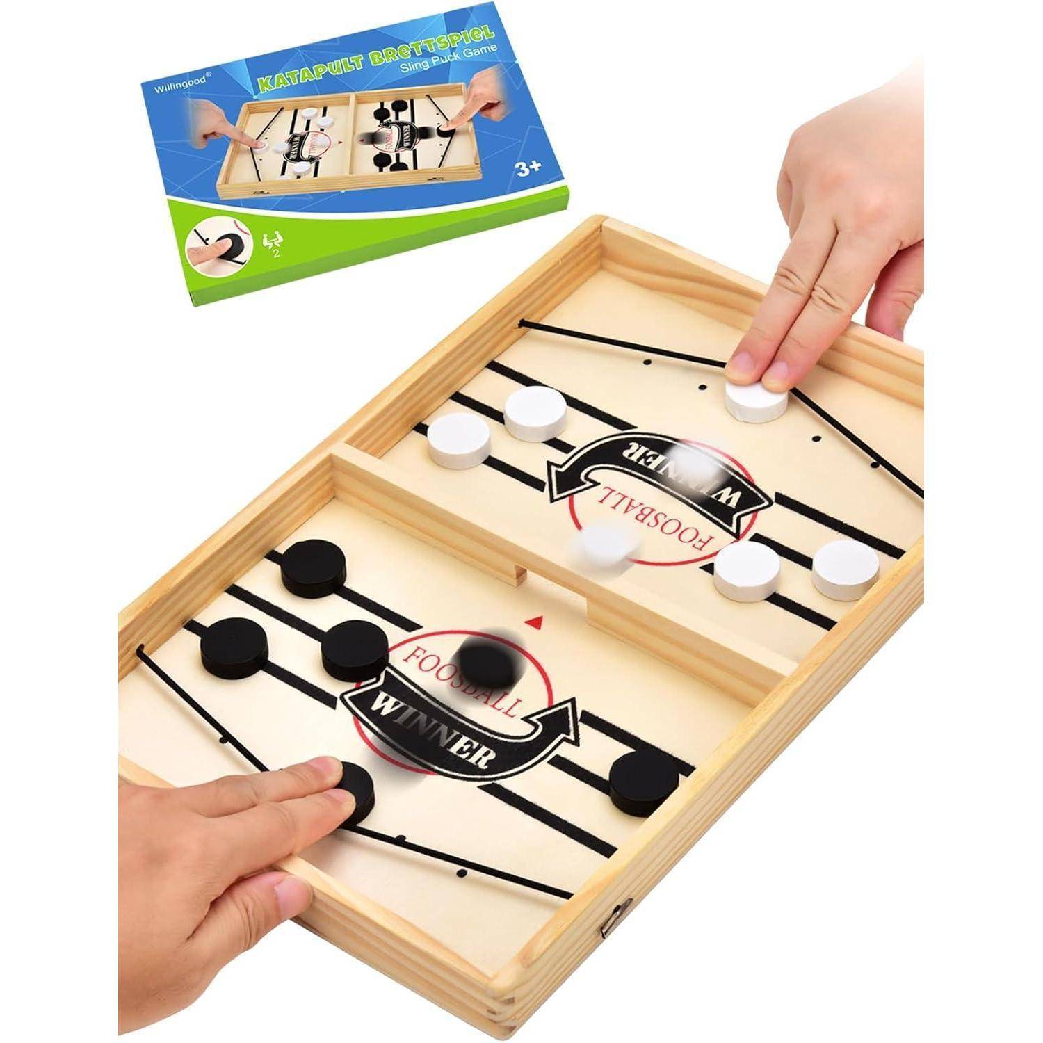Kinder, die ein schnelles Sling-Puck-Spiel auf einem Holzbrett mit schwarzen und weißen Pucks spielen. Spielebox mit der Aufschrift 