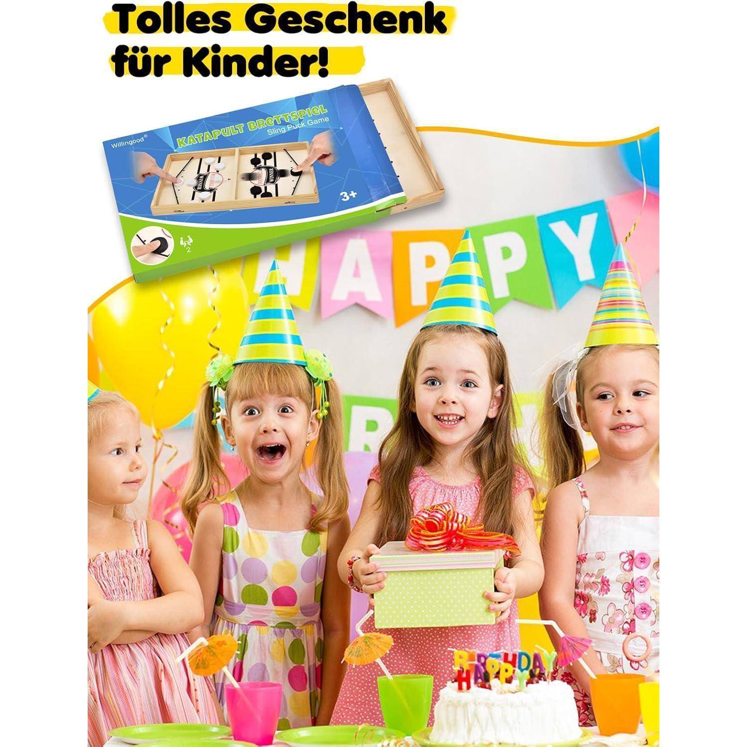 Vier Kinder mit Partyhüten stehen aufgeregt hinter einer Geburtstagstorte auf einem Tisch, mit bunten 