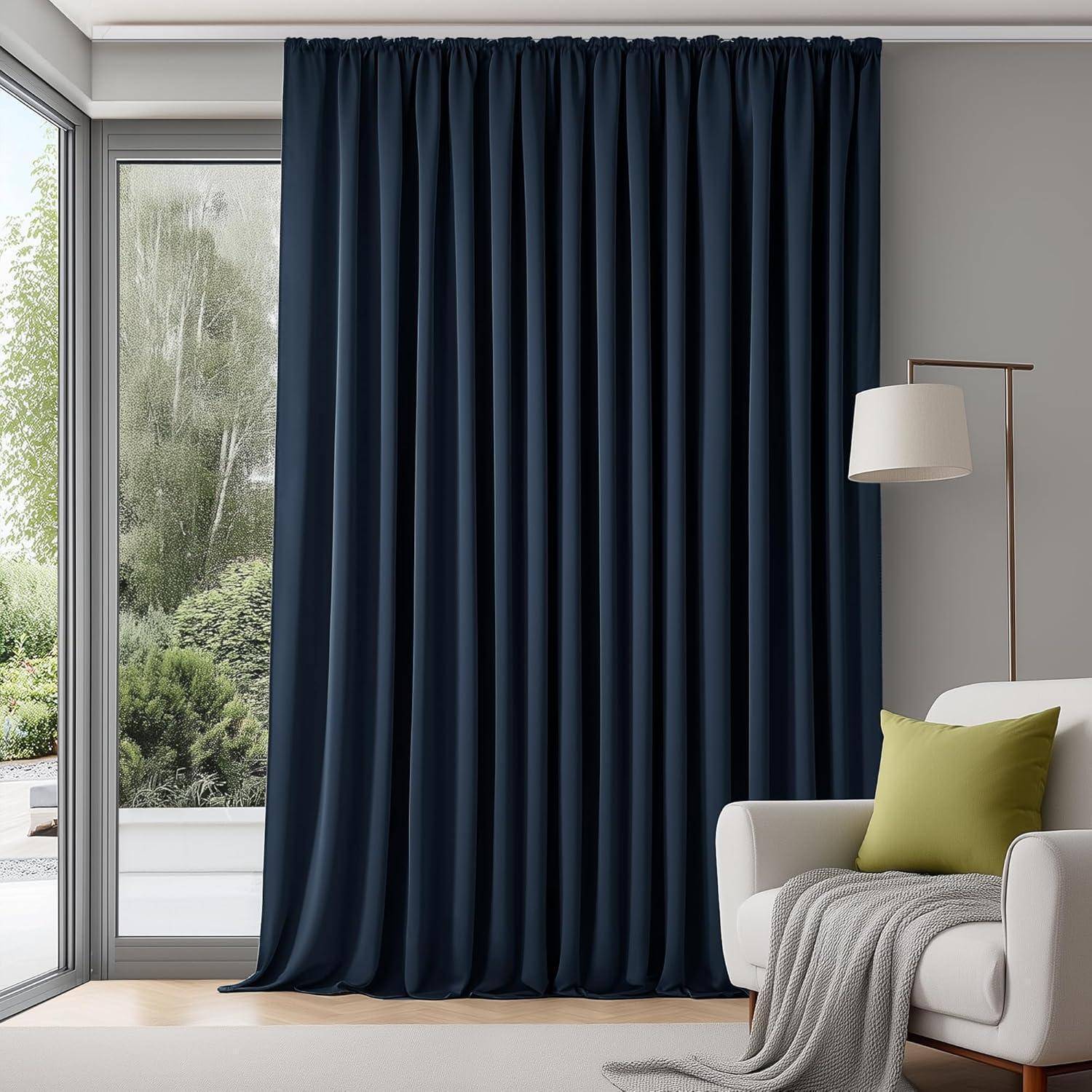 Ein Wohnzimmer mit einem großen Fenster, das von dunkelblauen Vorhängen verdeckt wird, ein Sessel mit grünen Kissen und eine Stehlampe daneben.