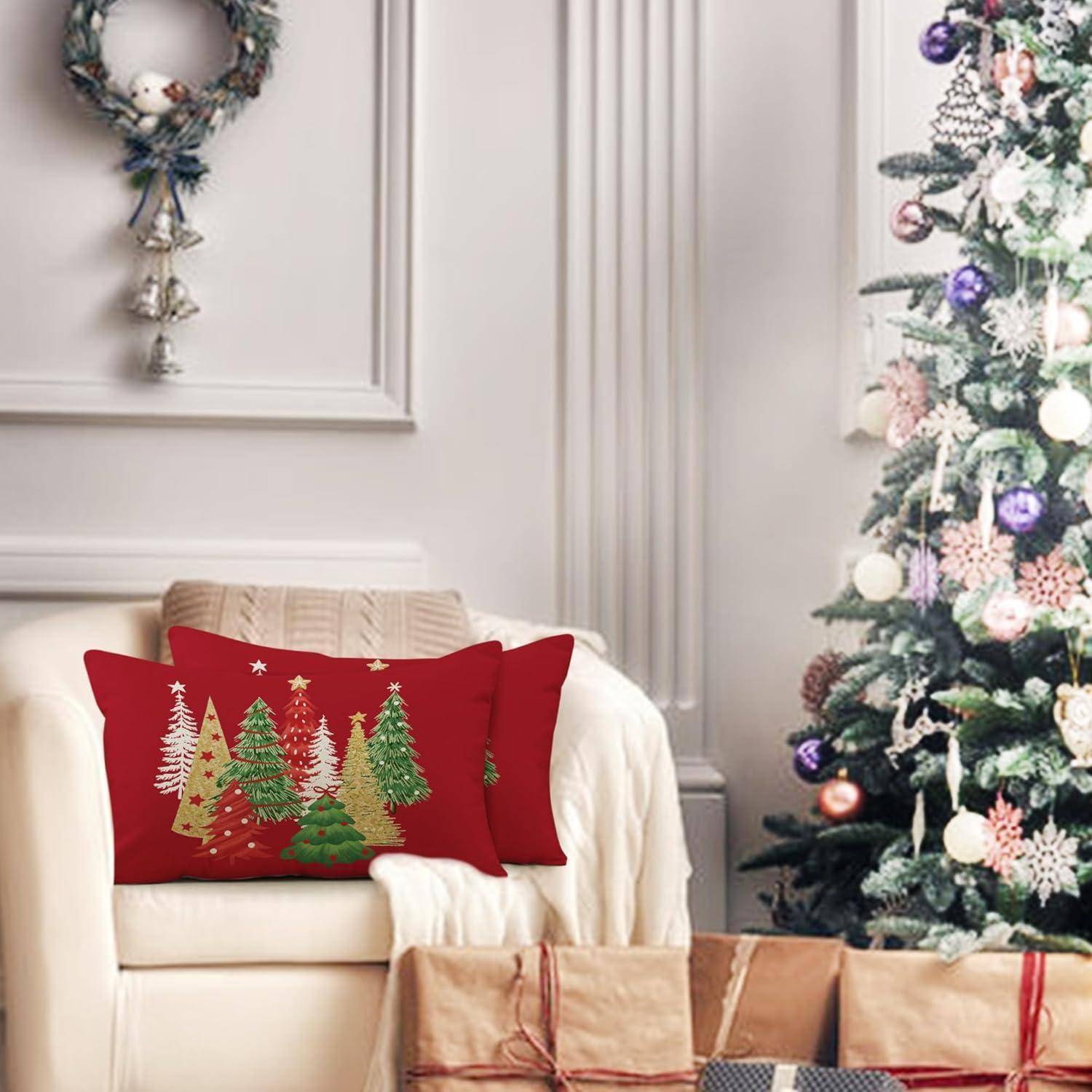 Ein Wohnzimmer, weihnachtlich geschmückt mit einem großen Baum, der mit Lichtern und Schmuck verziert ist, und einem Sofa mit roten Kissen, die Baumdesigns tragen.
