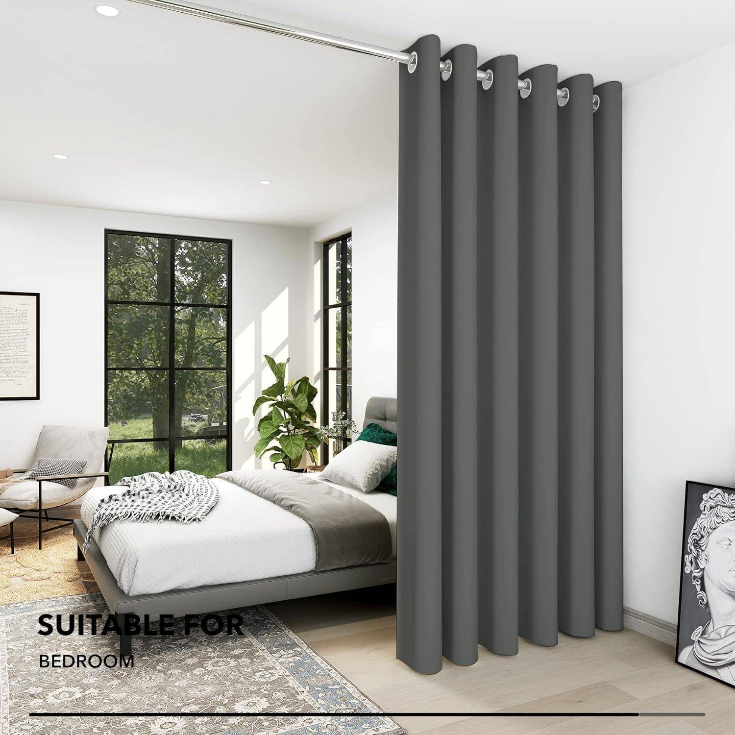 Graue Vorhänge hängen in einem modernen Schlafzimmer, während natürliches Licht hindurchfiltert. Der Raum umfasst ein Bett, einen Stuhl und dekorative Akzente.