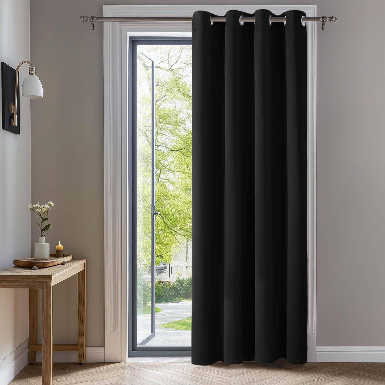 Ein sonnendurchfluteter Raum mit hellfarbenen Wänden zeigt einen Holzschreibtisch mit einer Blumenvase. Schwarze Vorhänge verdecken teilweise eine Tür und geben den Blick auf einen grünen, belaubten Baum draußen frei.