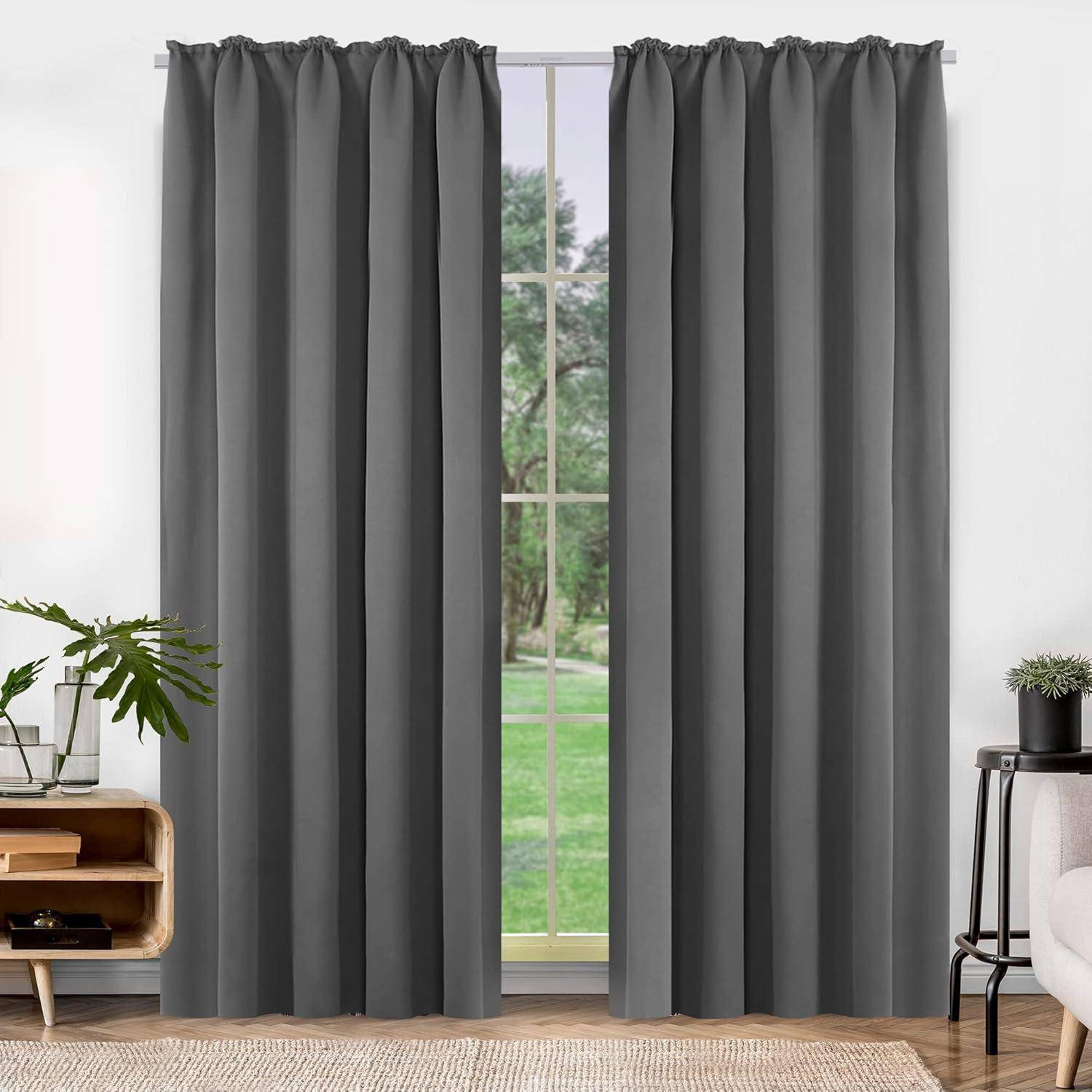 Ein Fenster mit grauen Vorhängen, teilweise geöffnet, um einen grünen Rasen und Bäume draußen zu offenbaren. Zimmerpflanzen und ein Beistelltisch befinden sich im Raum.