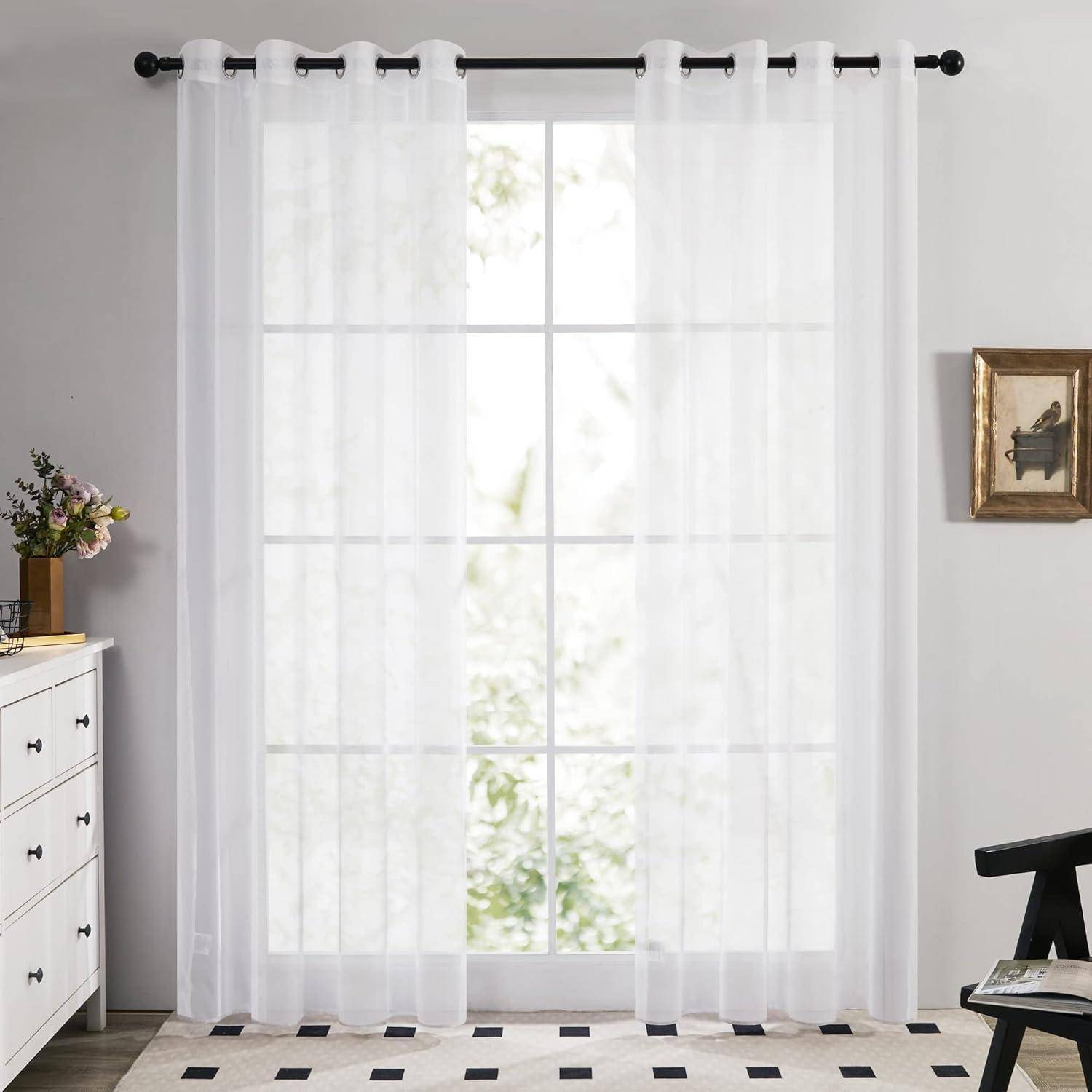 Weiße transparente Gardinen, die an einem Fenster hängen, mit durchsickerndem Licht, das eine weiche und luftige Atmosphäre in einem minimalistischen Raum erzeugt.