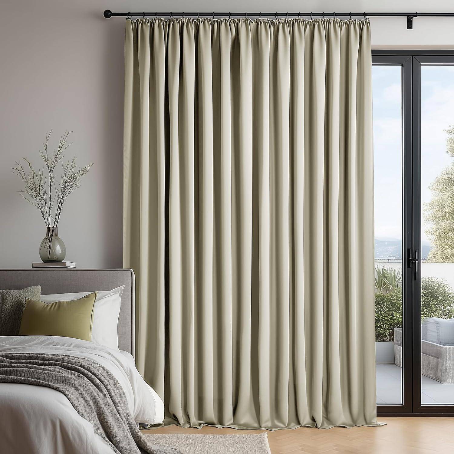 Ein ruhiges Schlafzimmer zeigt ein neutrales Bett, weiche Kissen und lange beige Vorhänge, die ein großes Fenster mit Blick in einen Garten umrahmen.