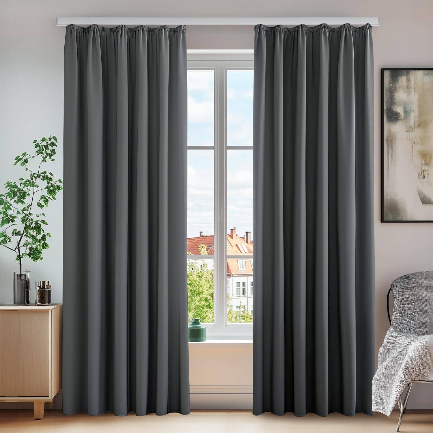 Ein Wohnzimmerfenster, gerahmt von grauen Vorhängen, bietet Ausblick auf Gebäude und Grünflächen. Links davon stehen eine Pflanze und ein Holzschrank, die die Dekoration vervollständigen.