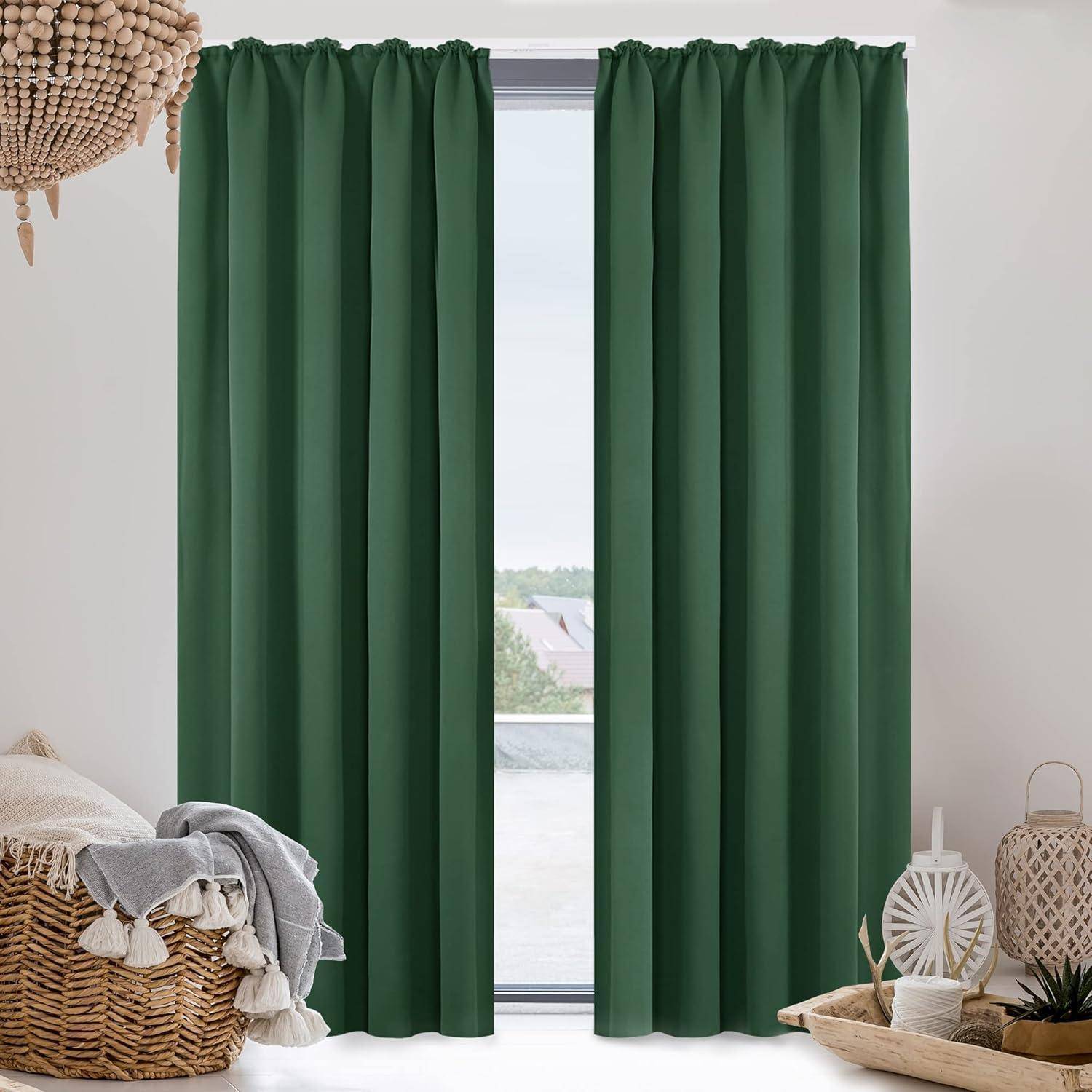 Ein moderner Wohnbereich mit grünen Vorhängen, die ein großes Fenster umrahmen und einen klaren Blick auf einen Balkon und darüber hinaus auf Dächer freigeben.