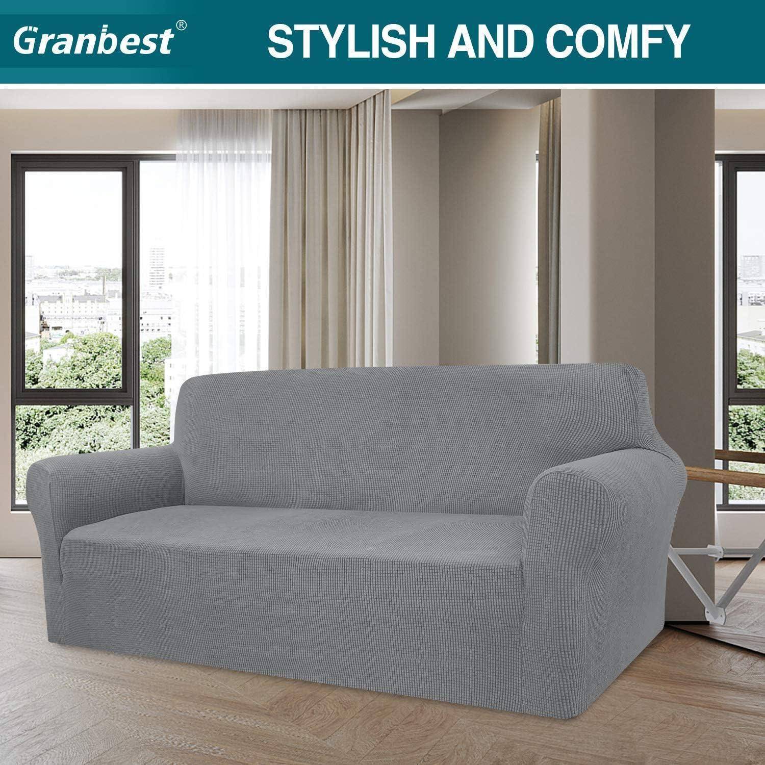 Graues Sofa mit Husse in einem modernen Wohnzimmer mit großen Fenstern und dem Text 