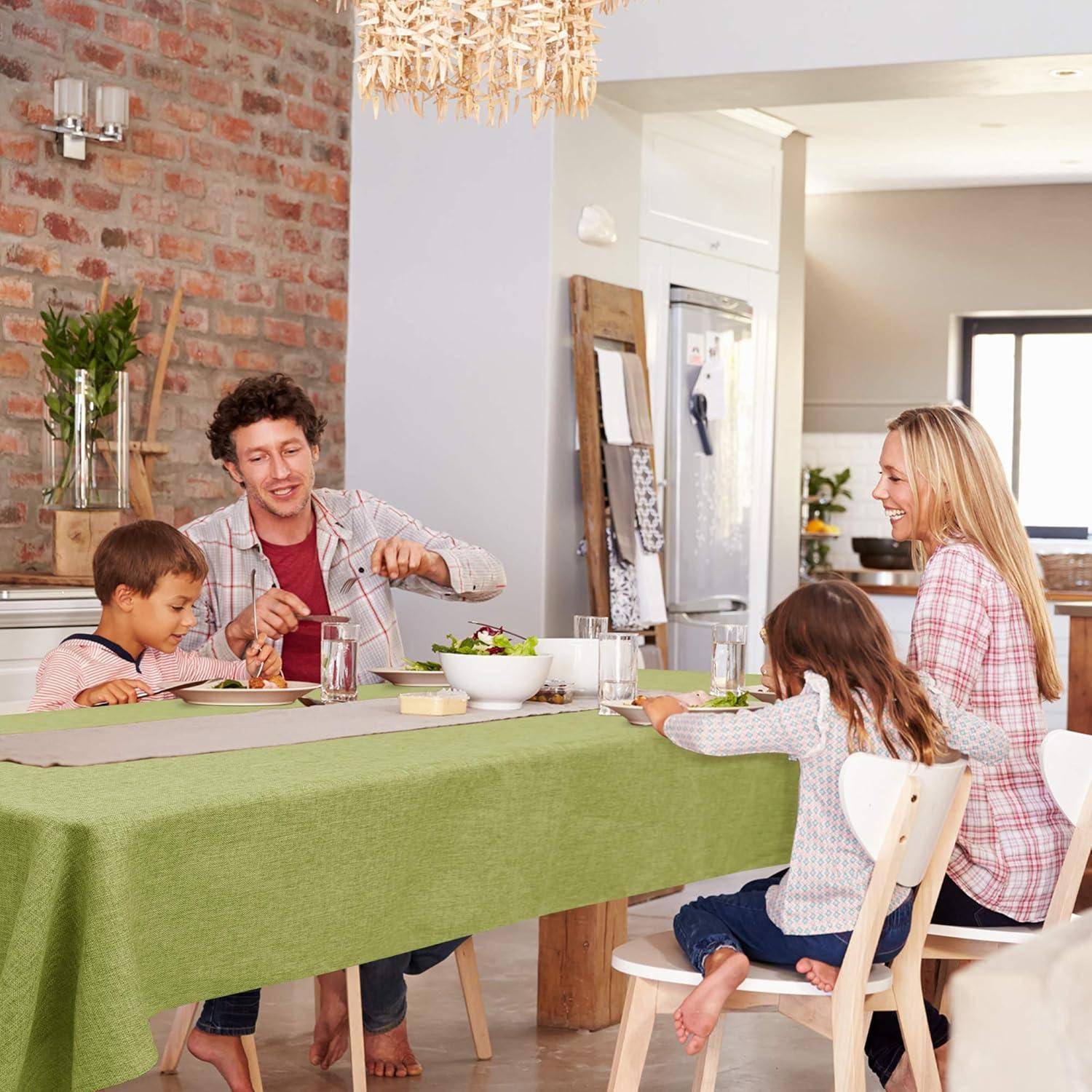 Eine Familie mit vier Personen sitzt um einen Esstisch und teilt eine Mahlzeit in einem hellen, gemütlichen Esszimmer. Eine hängende Lichtanlage sorgt für Wärme.