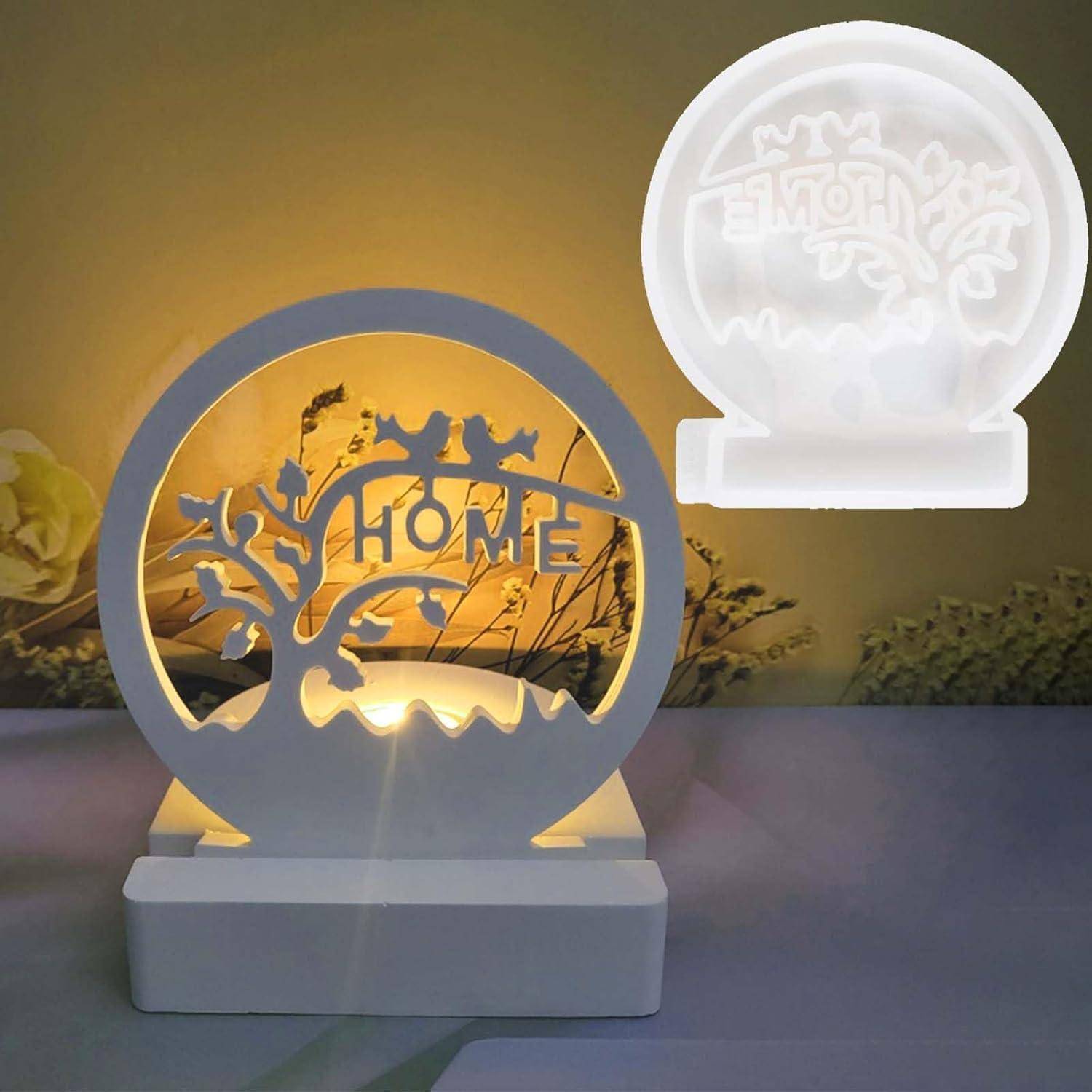 Eine dekorative Lampe mit einer Baumsilhouette und dem Wort 'HOME', von hinten warm beleuchtet, Schatten werfend.