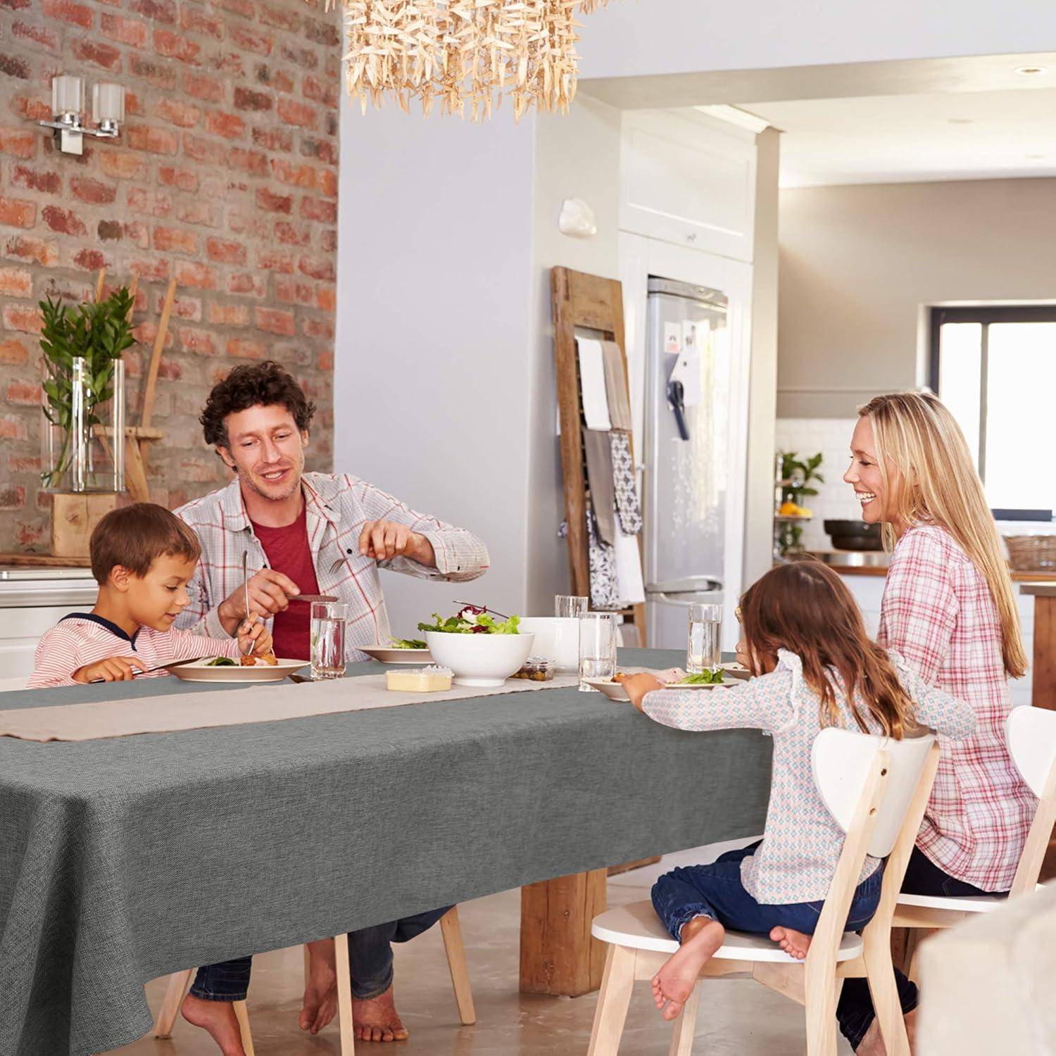 Eine vierköpfige Familie teilt eine Mahlzeit am Esstisch, lächelt und kommuniziert in einer warm beleuchteten Küche.