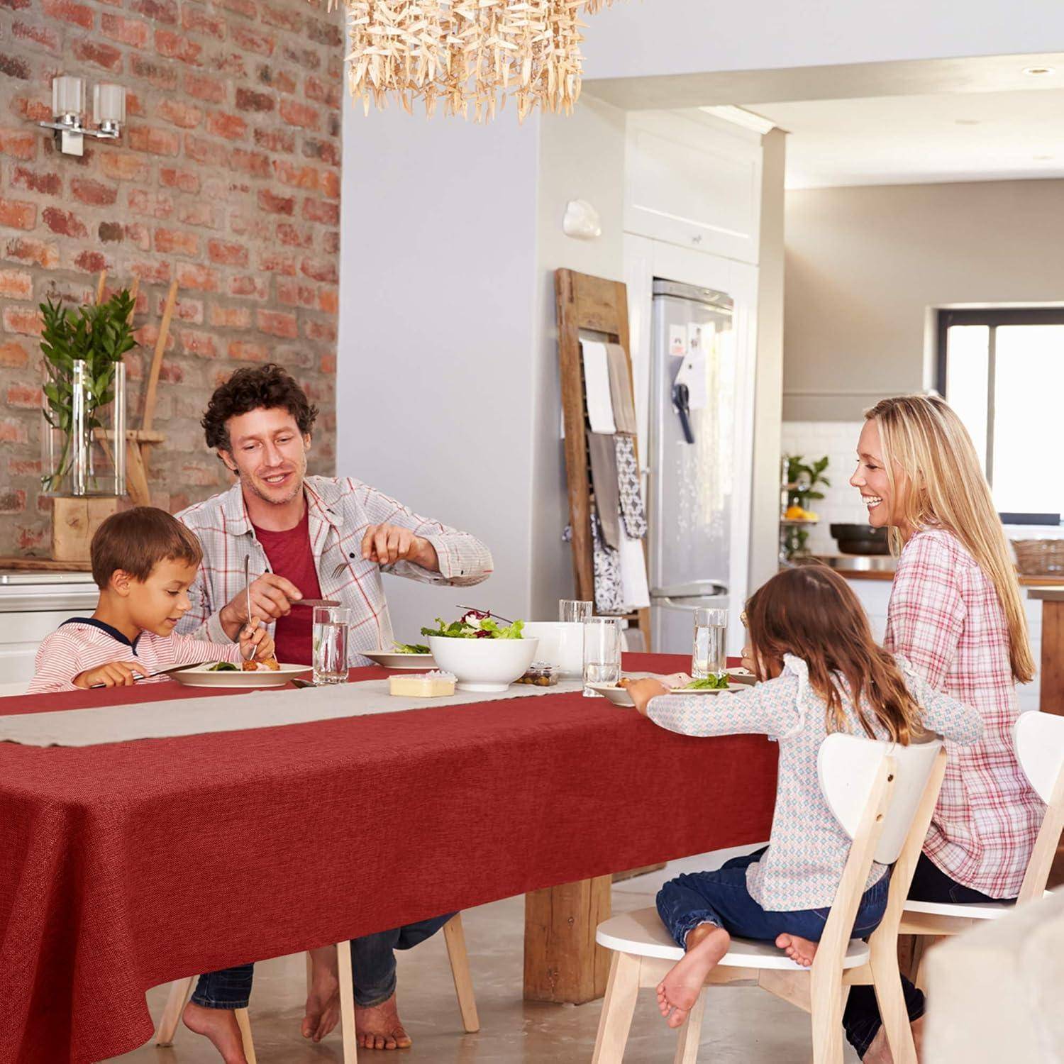 Eine vierköpfige Familie sitzt lächelnd um einen Esstisch und teilt eine Mahlzeit. Der Raum hat eine gemütliche, heimelige Atmosphäre.