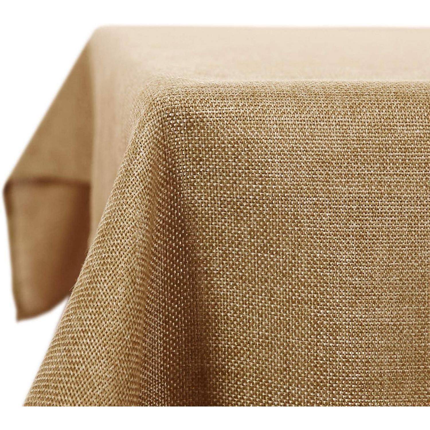 Eine beige, strukturierte Tischdecke, die über den Rand eines Tisches fällt und eine Nahaufnahme der Gewebetextur zeigt.