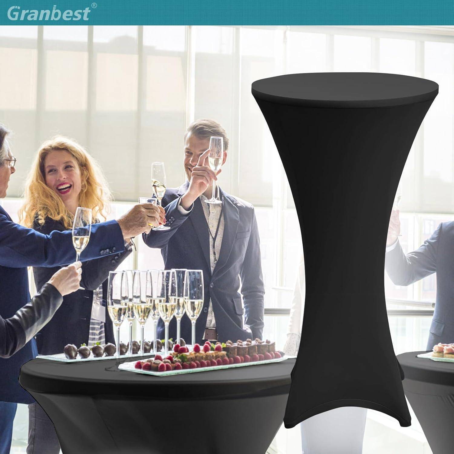 Eine Gruppe von Menschen in formeller Kleidung steht um einen Tisch mit Getränken, plaudernd und lächelnd, was auf eine Feierlichkeit oder Zusammenkunft hindeutet.