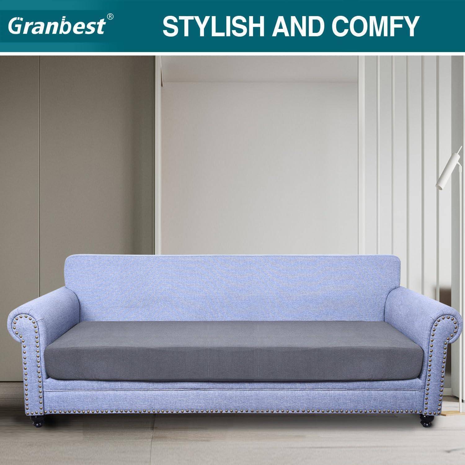 Ein hellblauer Sofa mit gerundeten Armlehnen und einem dunkelgrauen Sitzkissen steht in einem modernen Raum. Der Text darüber liest sich „STILVOLL UND GEMÜTLICH