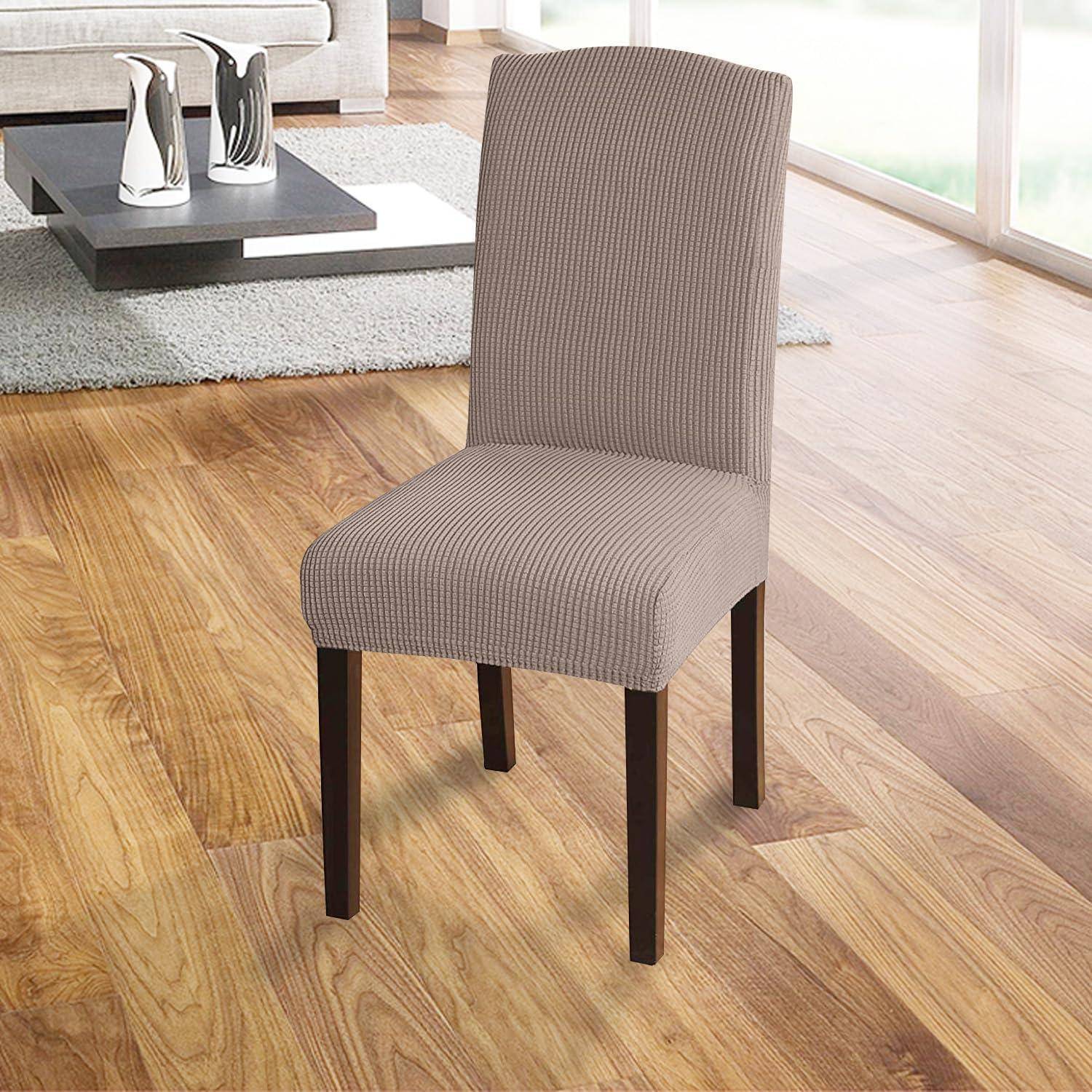 Ein beiger, gepolsterter Essstuhl mit dunklen Holzbeinen steht auf einem Holzboden, in der Nähe eines modernen Couchtisches mit dekorativen Gegenständen.