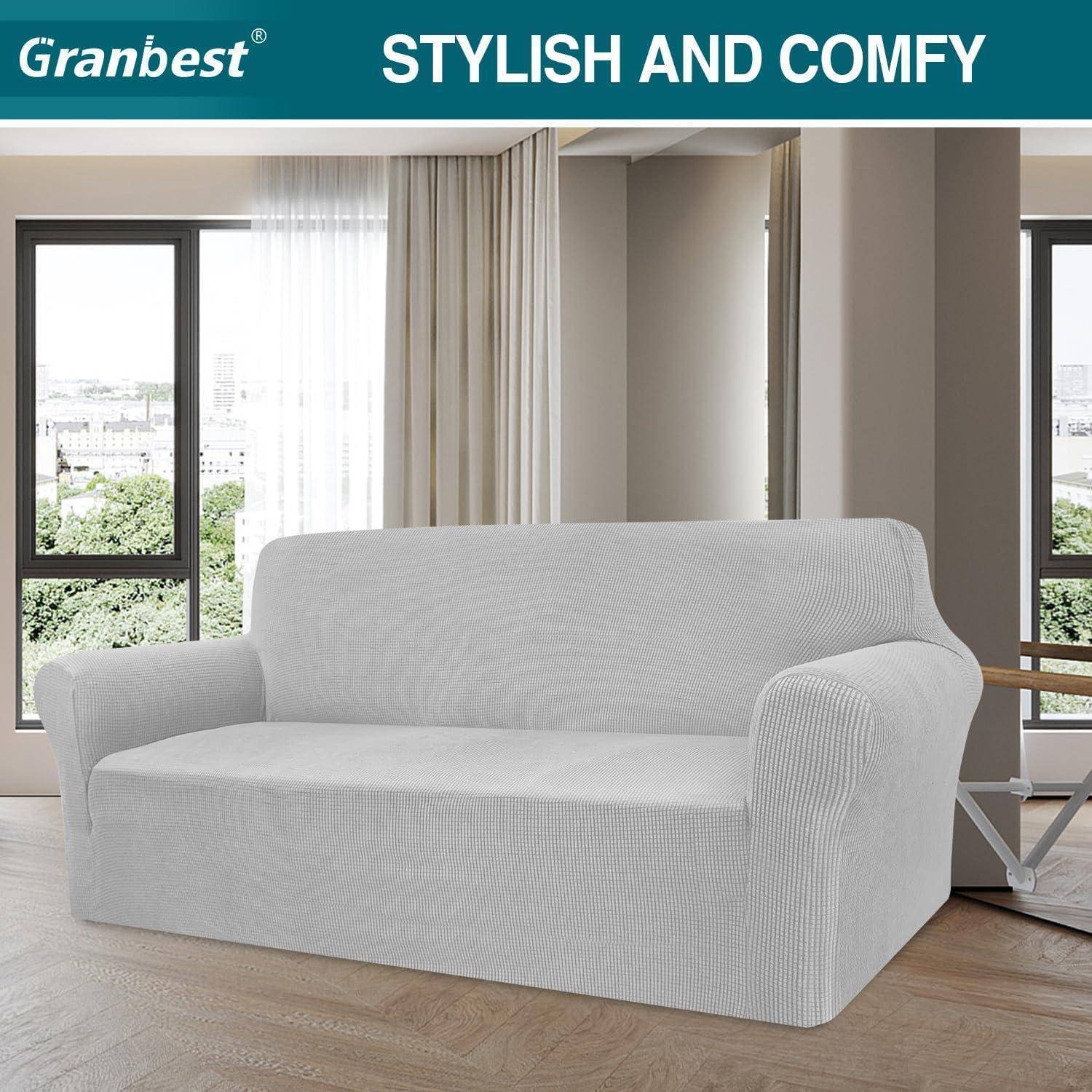 Ein weißes Sofa mit einem maßgeschneiderten Bezug steht in einem modernen Wohnzimmer mit großen Fenstern. Text darüber liest sich: 'STILVOLL UND GEMÜTLICH'.