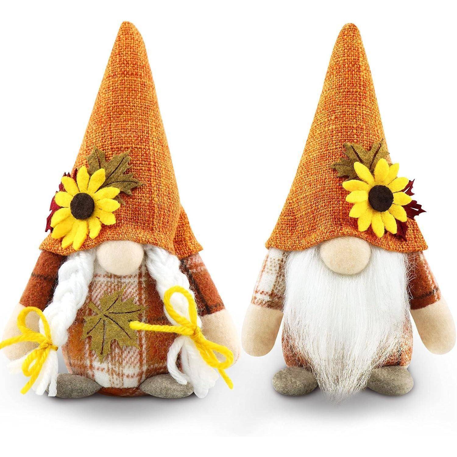 Zwei Plüschzwerge mit langen weißen Bärten, die orangefarbene Hüte mit Sonnenblumen tragen. Einer hält einen gelben Schnurbogen.