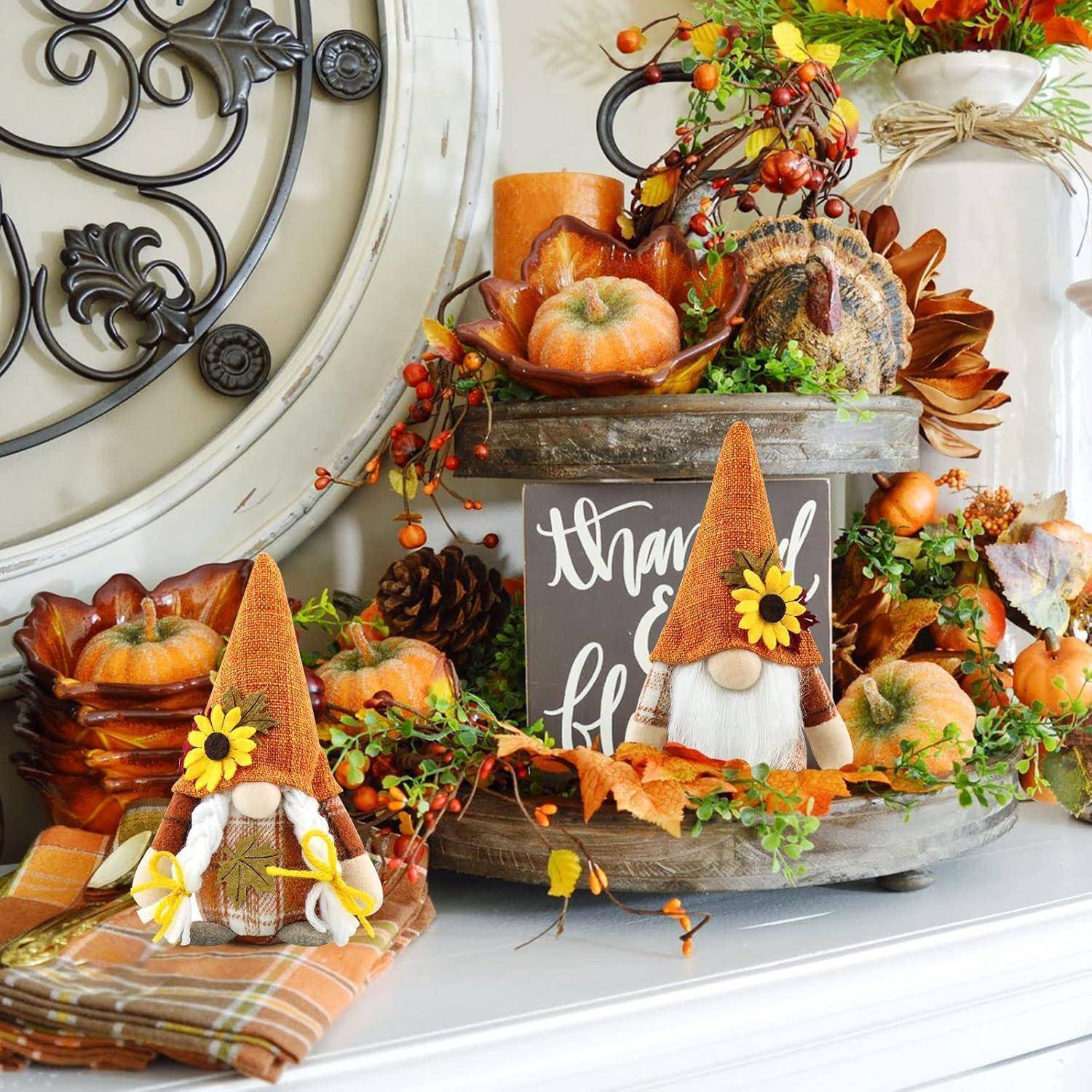 Herbstliche Dekoration mit Kürbissen, Sonnenblumen, Beeren und Gartenzwerg-Figuren. Der Hintergrund enthält ein Schild mit der Aufschrift 