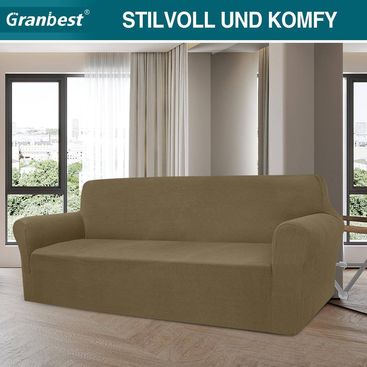 Ein braunes gepolstertes Sofa in einem Wohnzimmer mit großen Fenstern, die einen Blick auf die Stadtlandschaft nach draußen eröffnen.