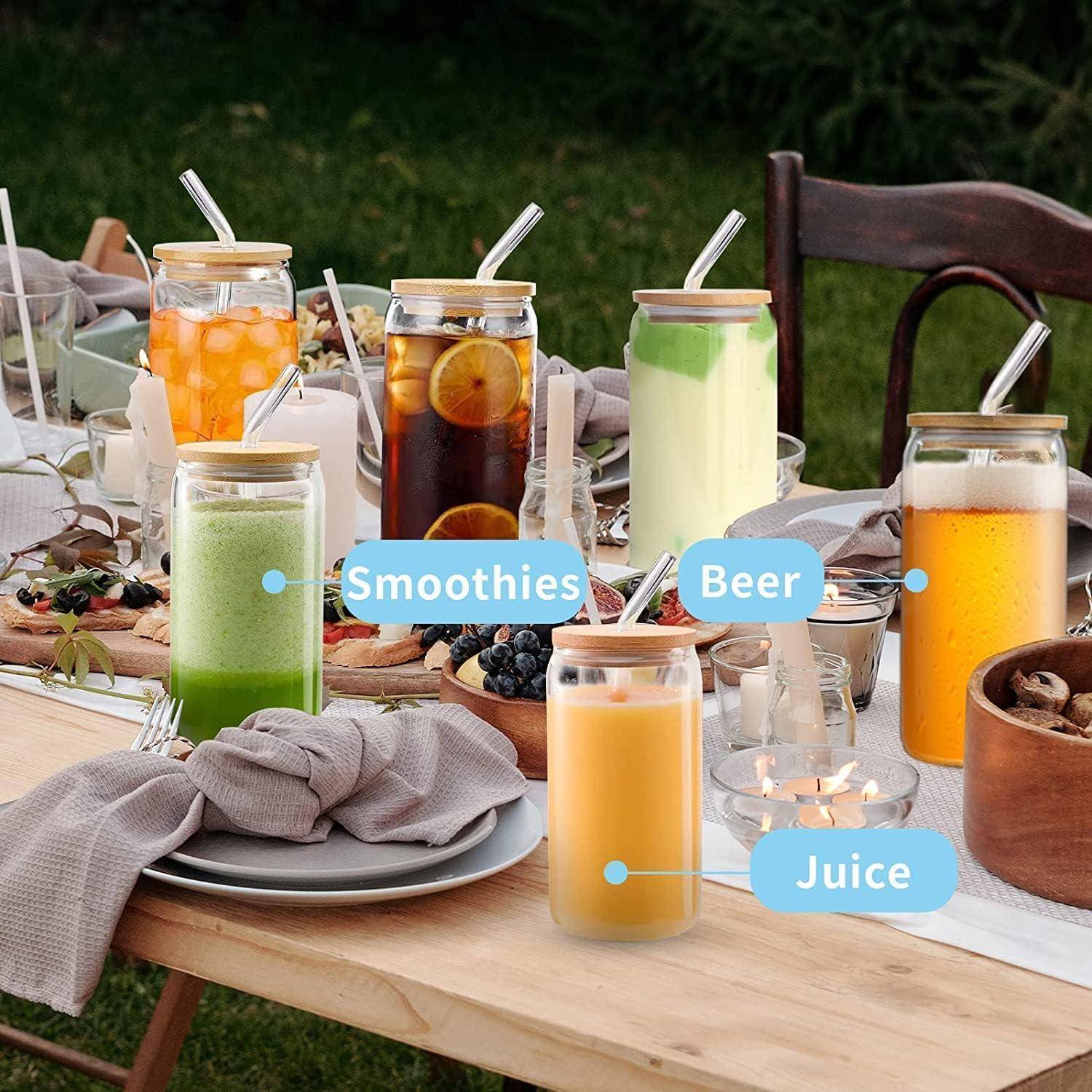 Ein draußen gedeckter Tisch mit Smoothies, Bier und Saft in Glasgefäßen. Jedes Getränk ist beschriftet. Teller und Besteck sind drumherum angeordnet.
