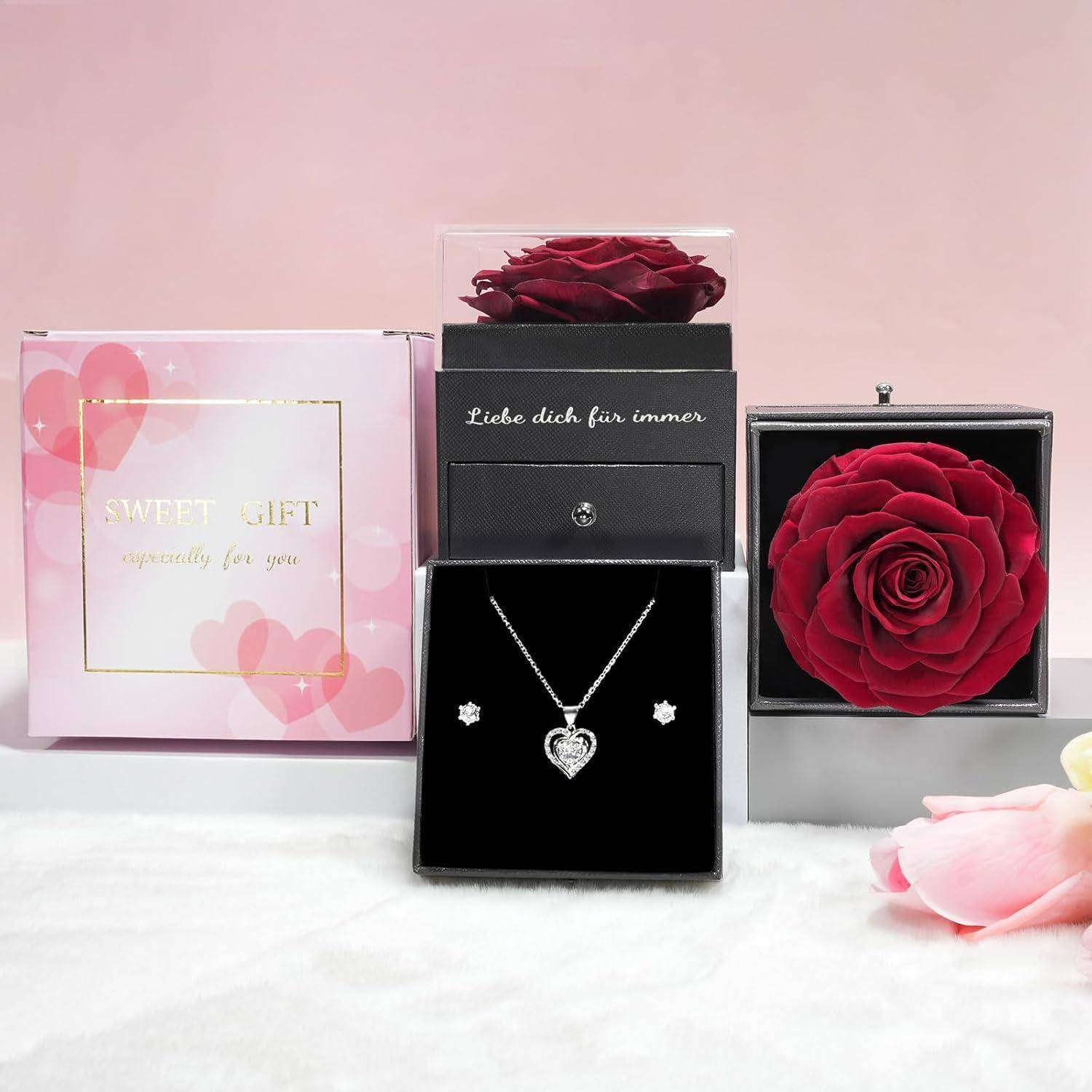 Geschenkset mit einer Halskette und Ohrringen, die neben einer Rose in einer Box und einer rosa Verpackung mit der Aufschrift „Süßes Geschenk, besonders für dich