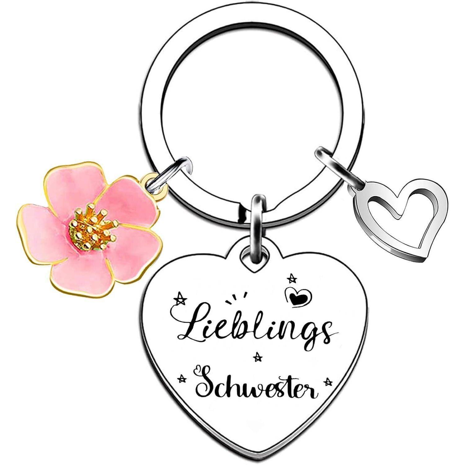 Herzförmiger Schlüsselanhänger-Charm mit 'Lieblings Schwester' Text, rosa Blumen-Charm und Herz-Umriss-Charm.