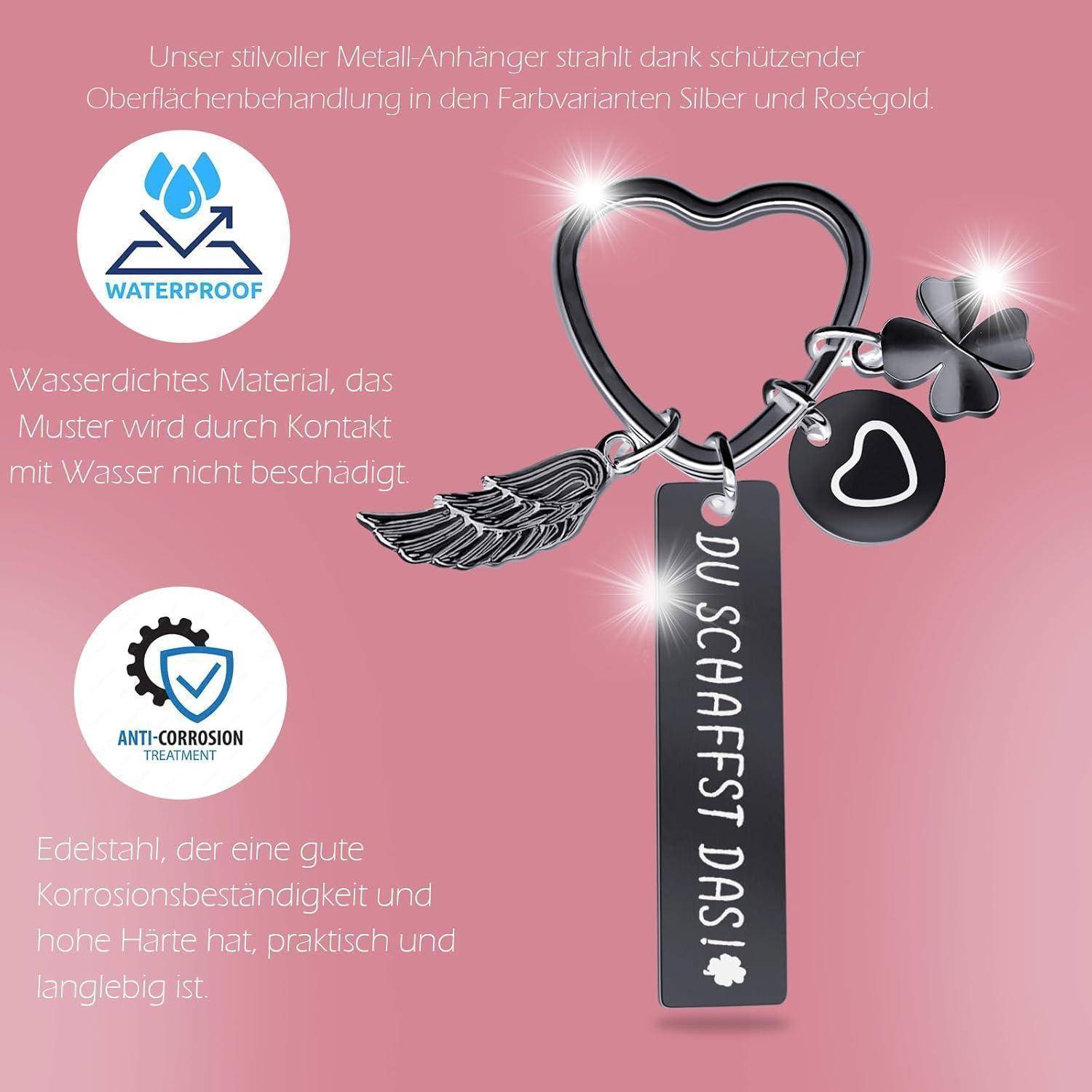Herzförmiger Metall-Schlüsselanhänger mit Feder- und Glücksklee-Anhängern. Text: 'DU SCHAFFST DAS'. Eigenschaften: wasserdicht, korrosionsbeständig.