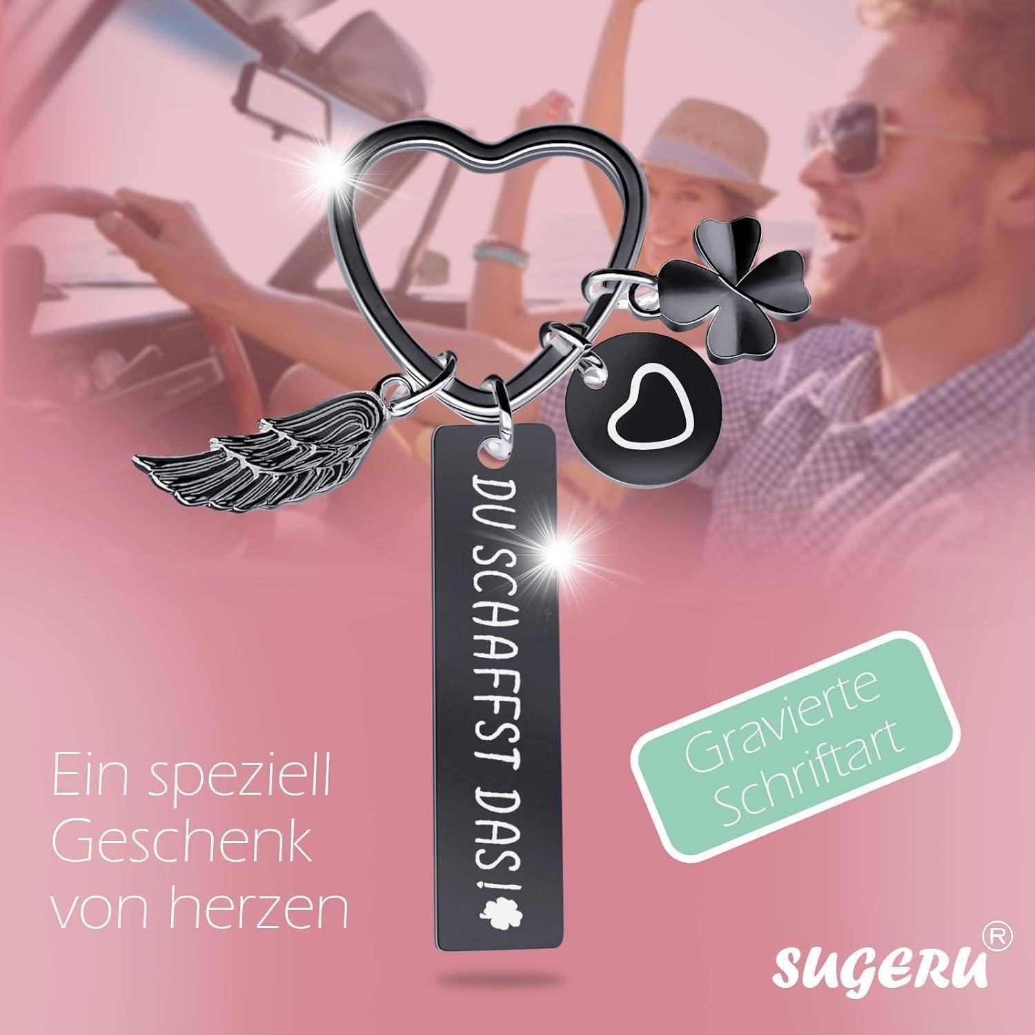 Ein herzförmiger Schlüsselanhänger mit einem Glücksklee mit vier Blättern, einem Flügelanhänger und einem gravierten Anhänger mit der Aufschrift 