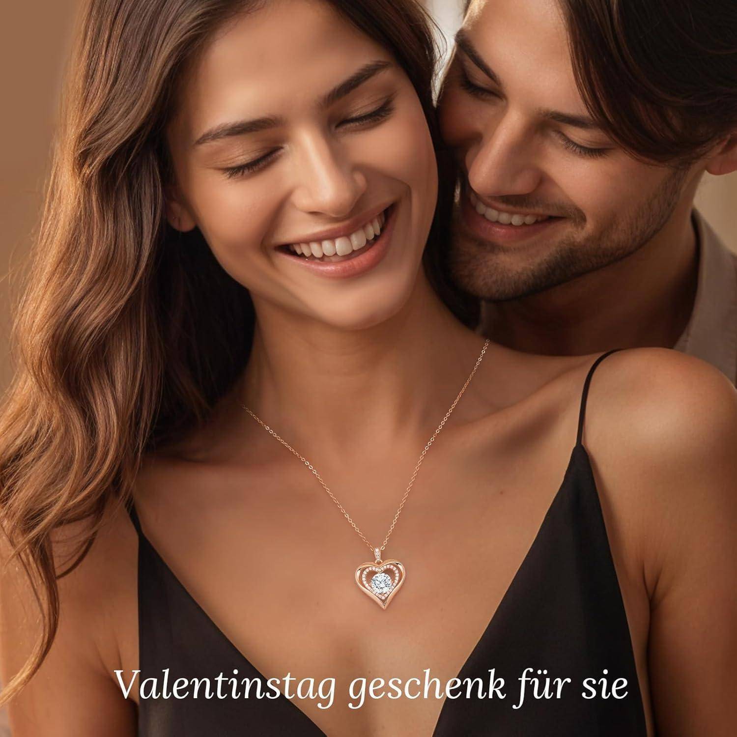 Ein lächelndes Paar, wobei die Frau eine herzförmige Halskette trägt. Text lautet: 'Valentinstag Geschenk für sie'.