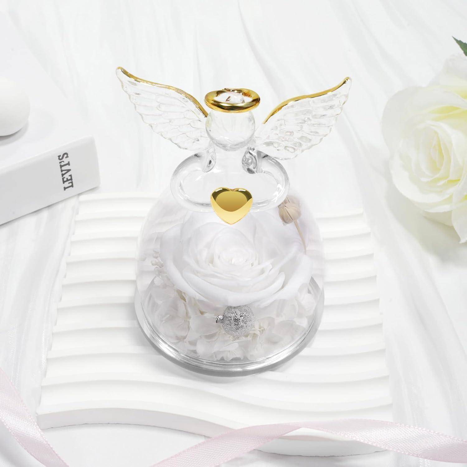 Eine Glasengelfigur mit goldenen Akzenten umschließt eine weiße Rose und Schmuckstücke im Inneren. In der Nähe sind eine Rose und ein Markenbrandprodukt zu sehen.