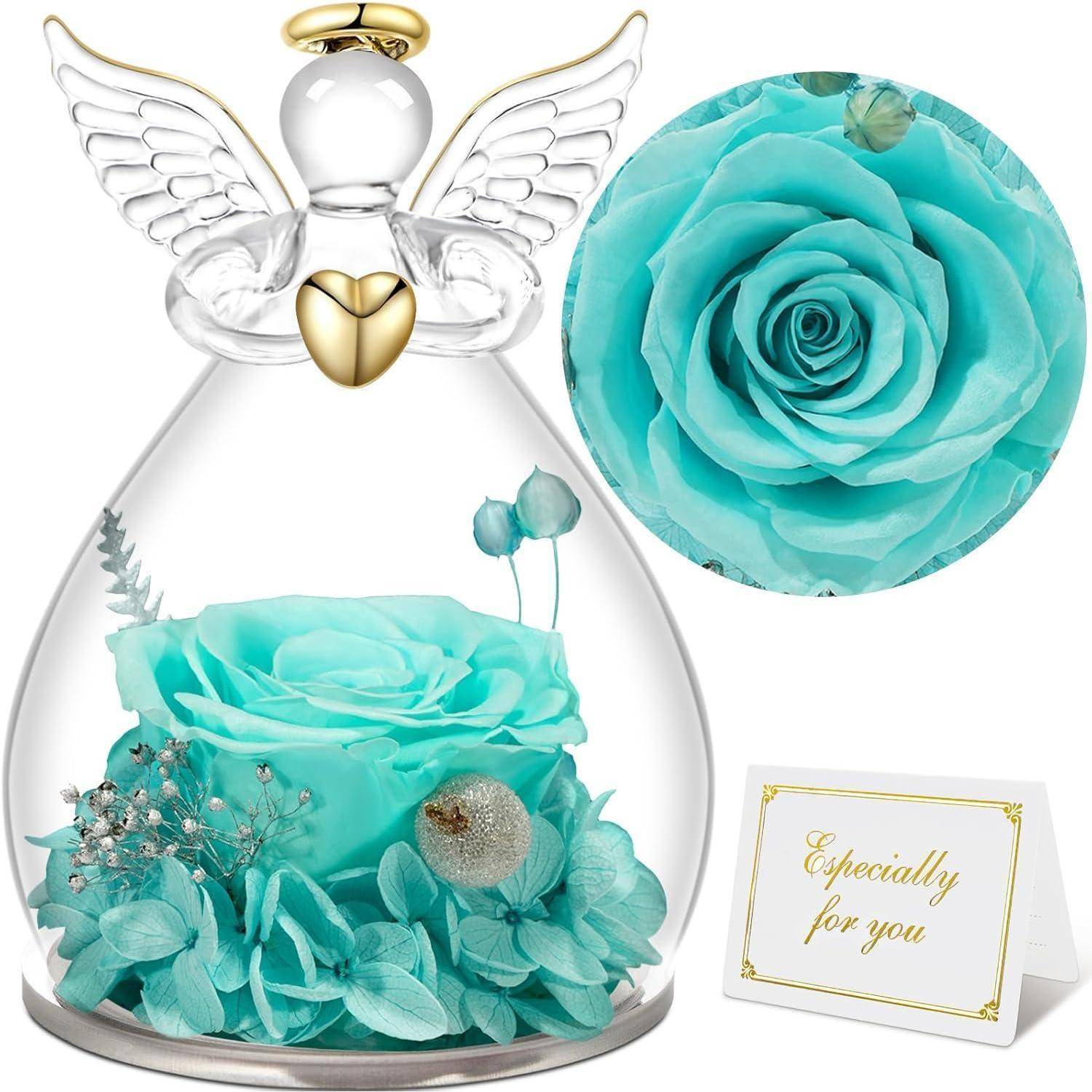 Eine konservierte türkisfarbene Rose in einer Glaskuppel mit Flügeln eines Engels und einem goldenen Herz, begleitet von einer Karte mit der Aufschrift 