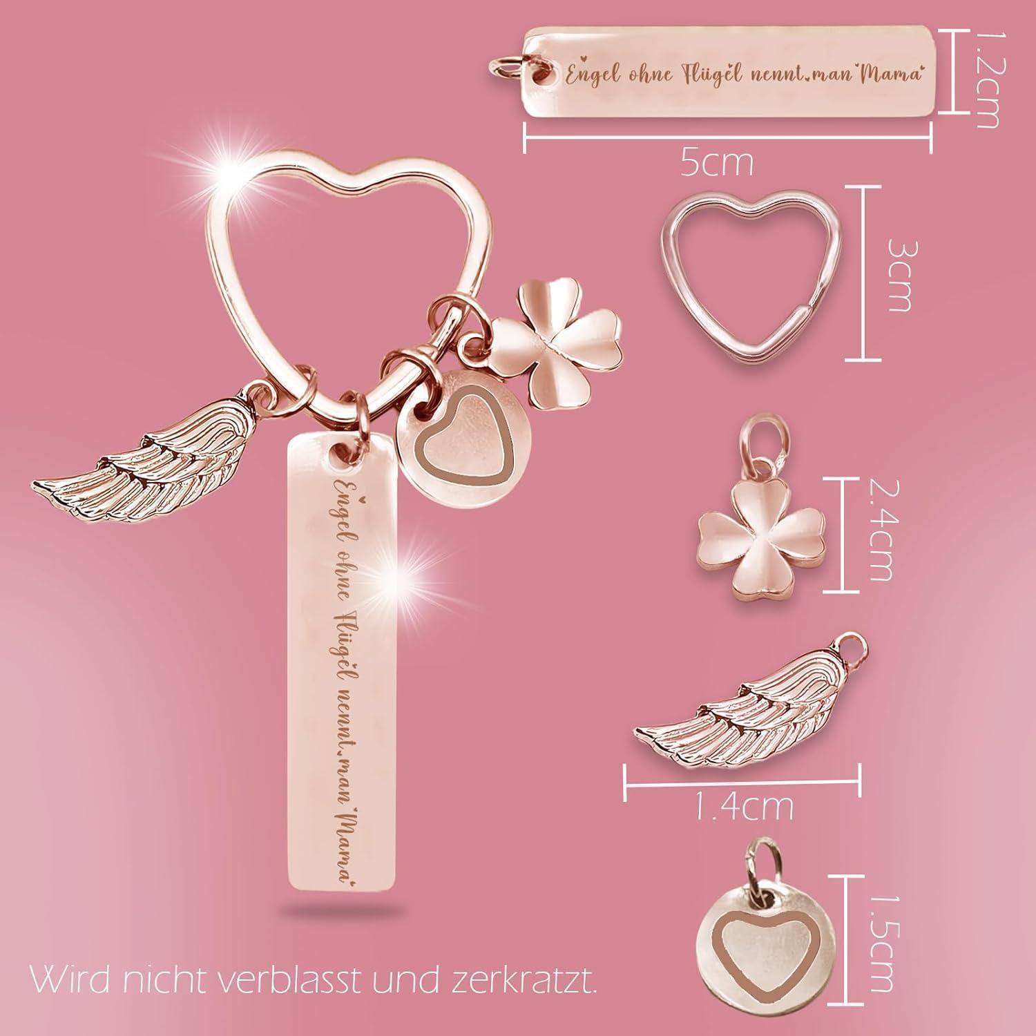 Ein Roségold-Schlüsselanhänger zeigt einen Herzring mit Anhängern: eine Feder, ein vierblättriges Kleeblatt und ein Herz, zusammen mit einem Balken, der mit 'Engel ohne Flügel nennt man Mama' graviert ist.